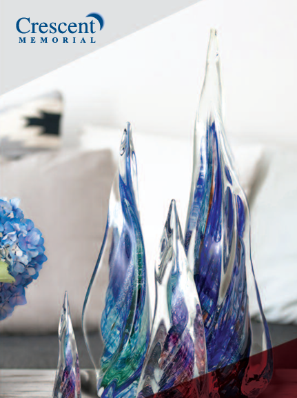 a group of glass sculptures are sitting on a table next to a vase of flowers .