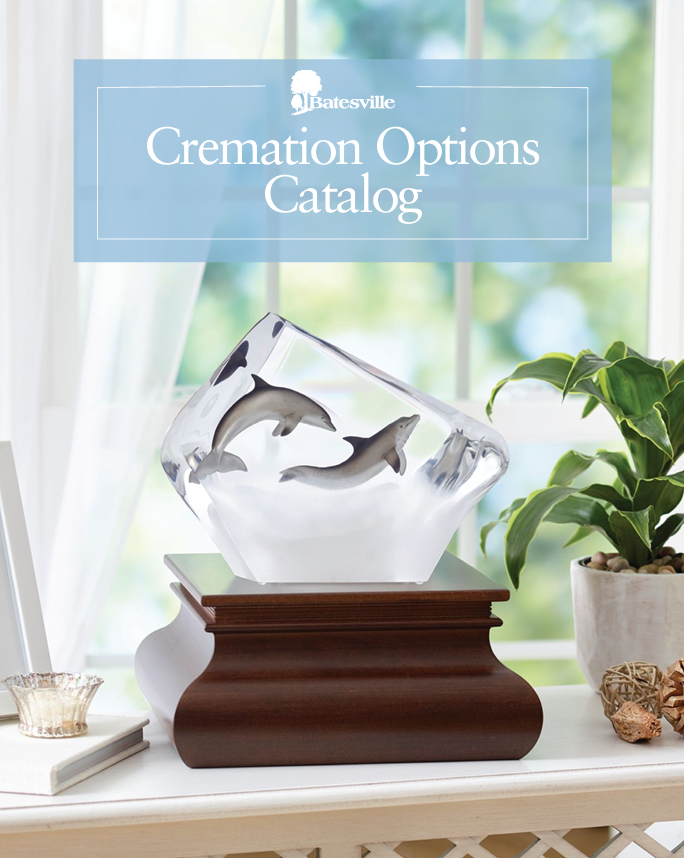 a catalog for cremation options shows a glass sculpture of two dolphins