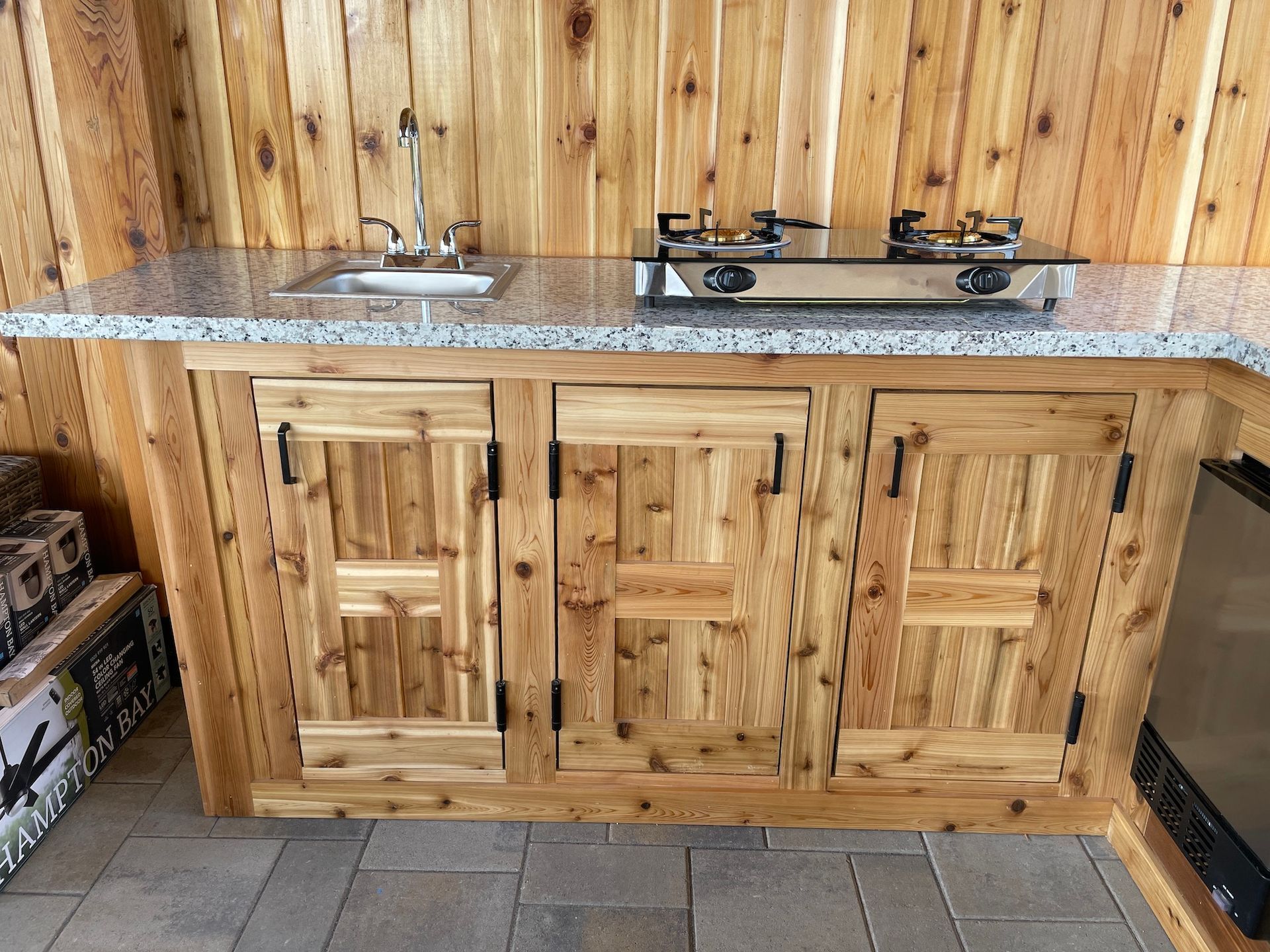 A kitchen with wooden cabinets , a sink , and a stove top oven.