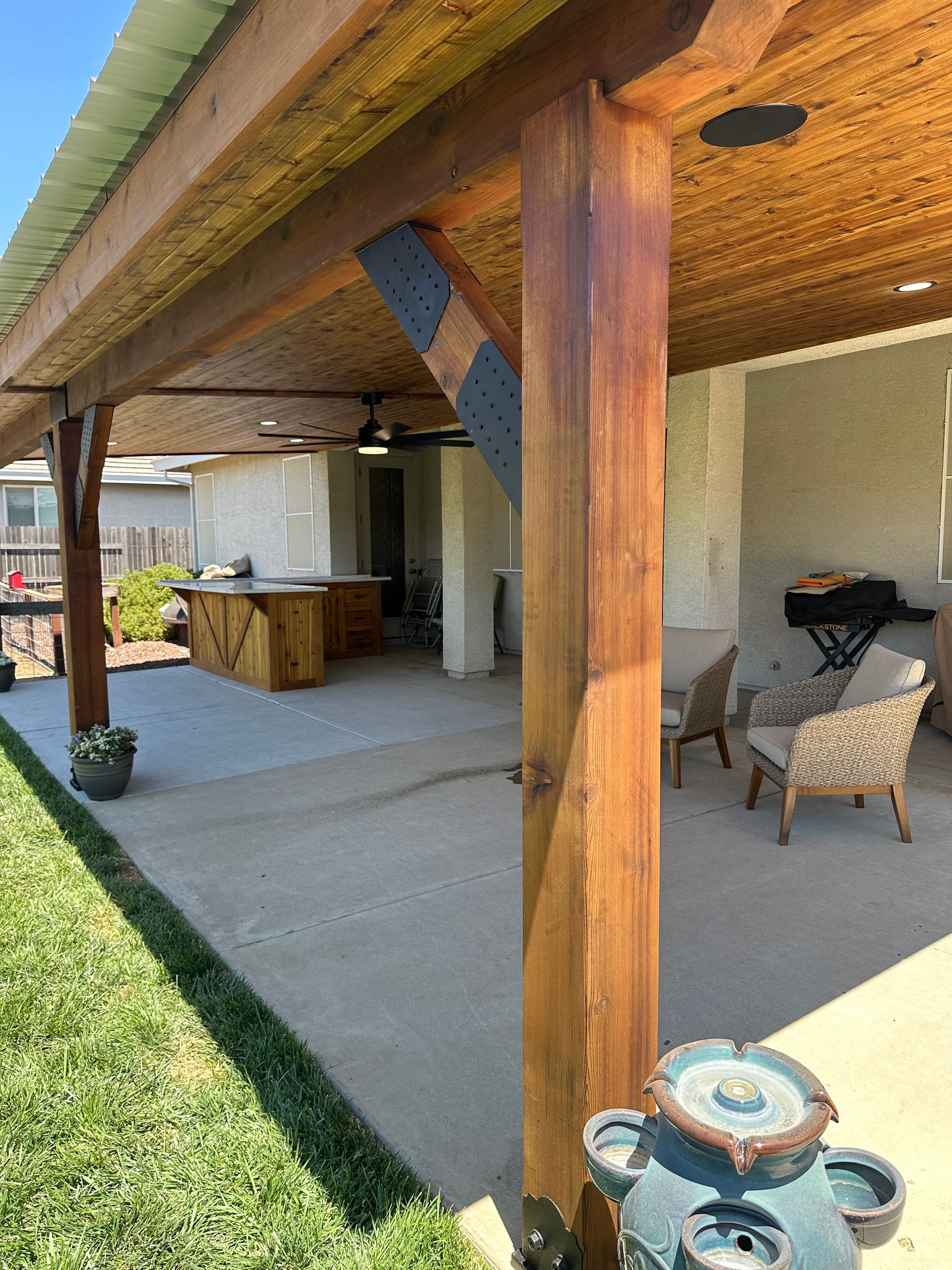A covered patio with a wooden ceiling and a fountain.