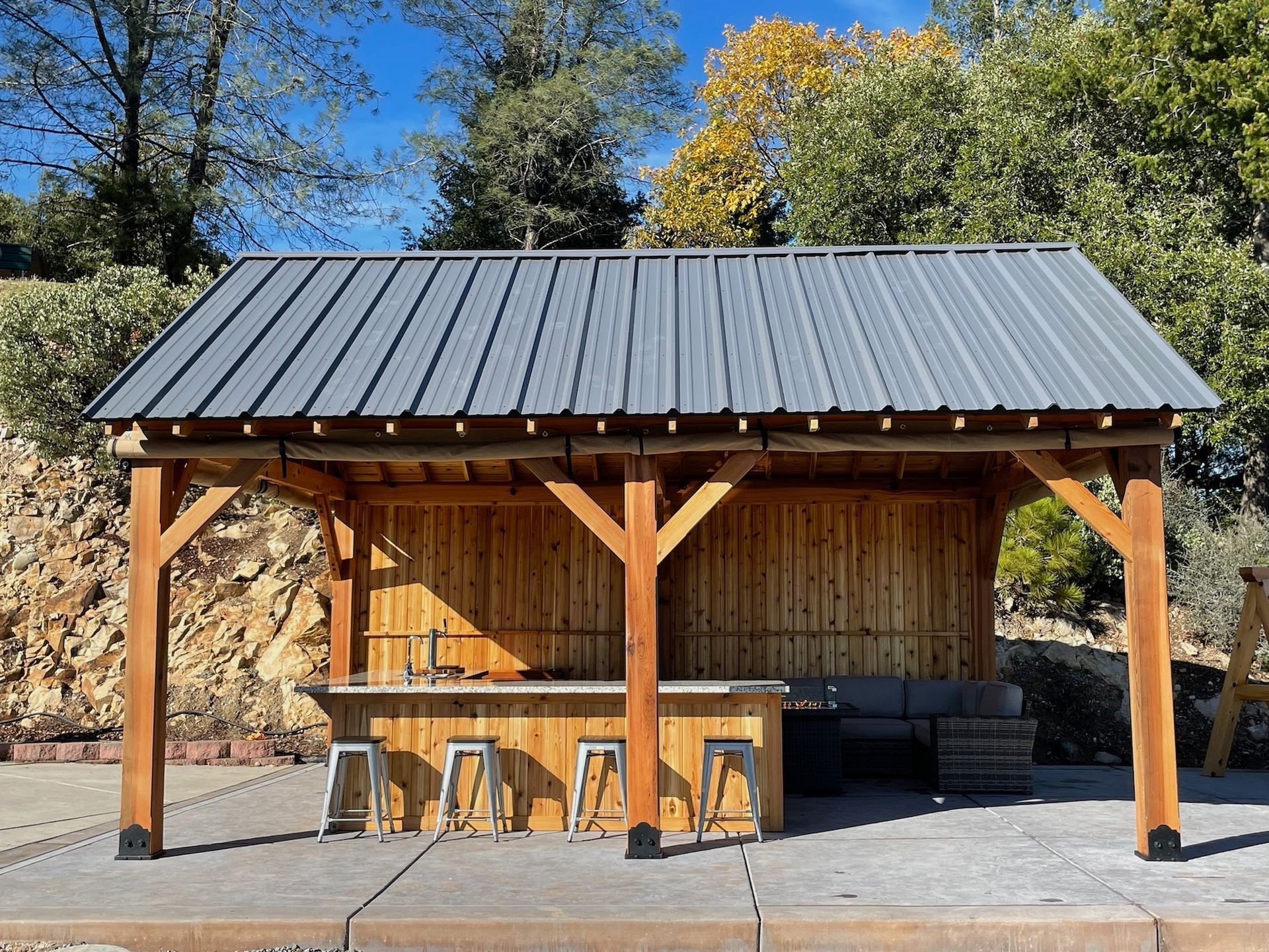 A wooden structure with a metal roof and a bar underneath it