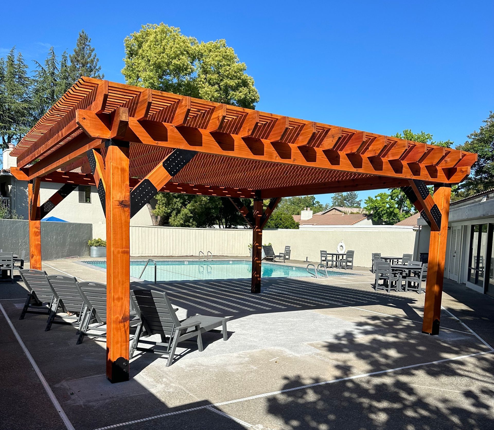 A large wooden pergola over a swimming pool