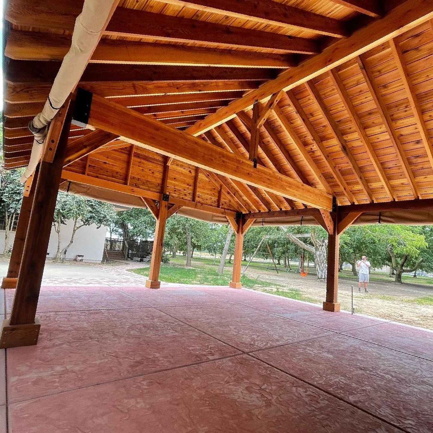A large wooden structure with a red concrete floor