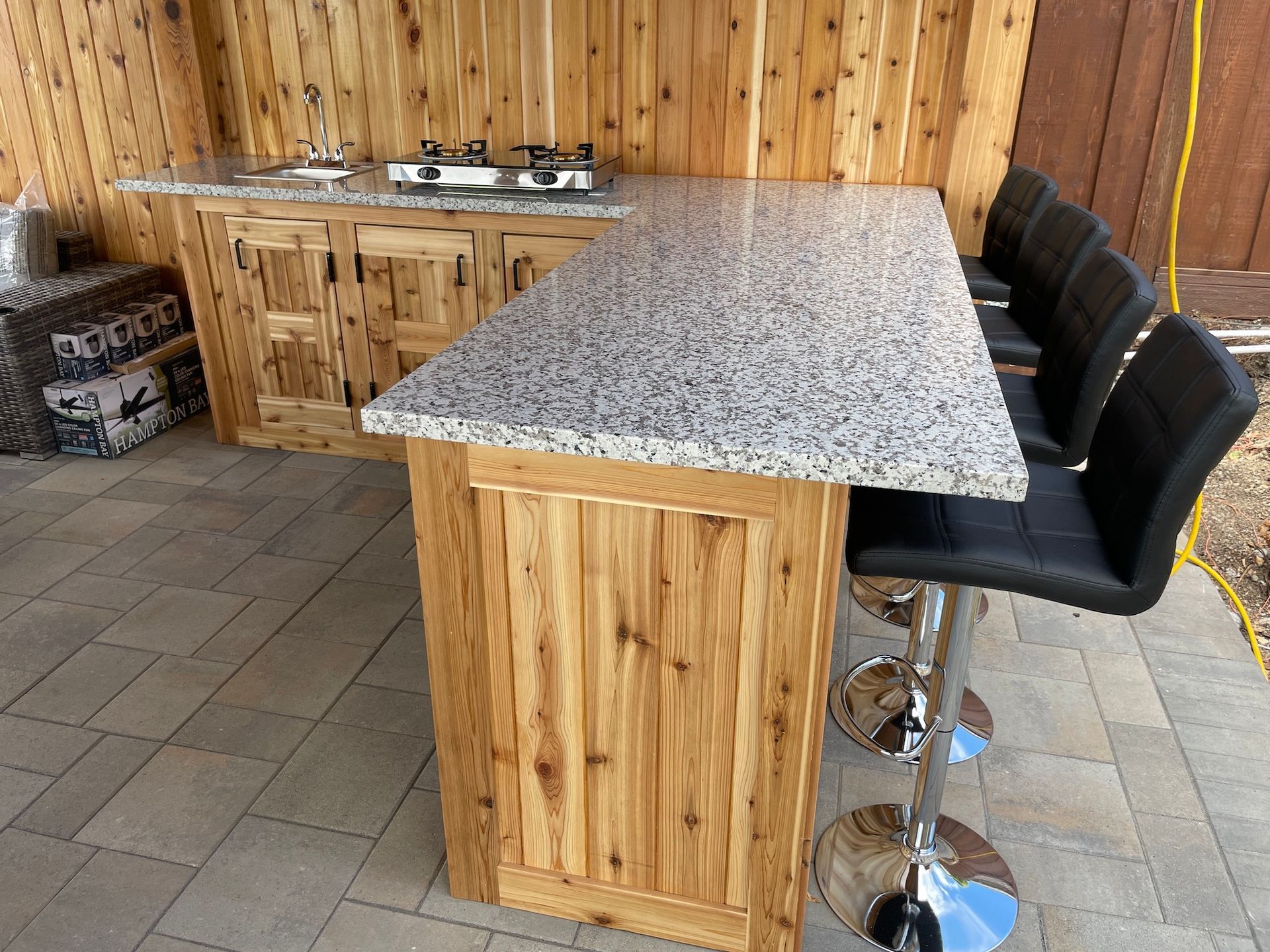 A kitchen with a granite counter top and wooden cabinets.