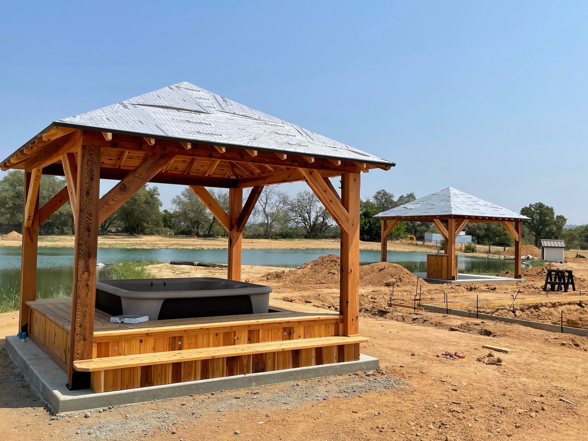A wooden gazebo with a hot tub underneath it