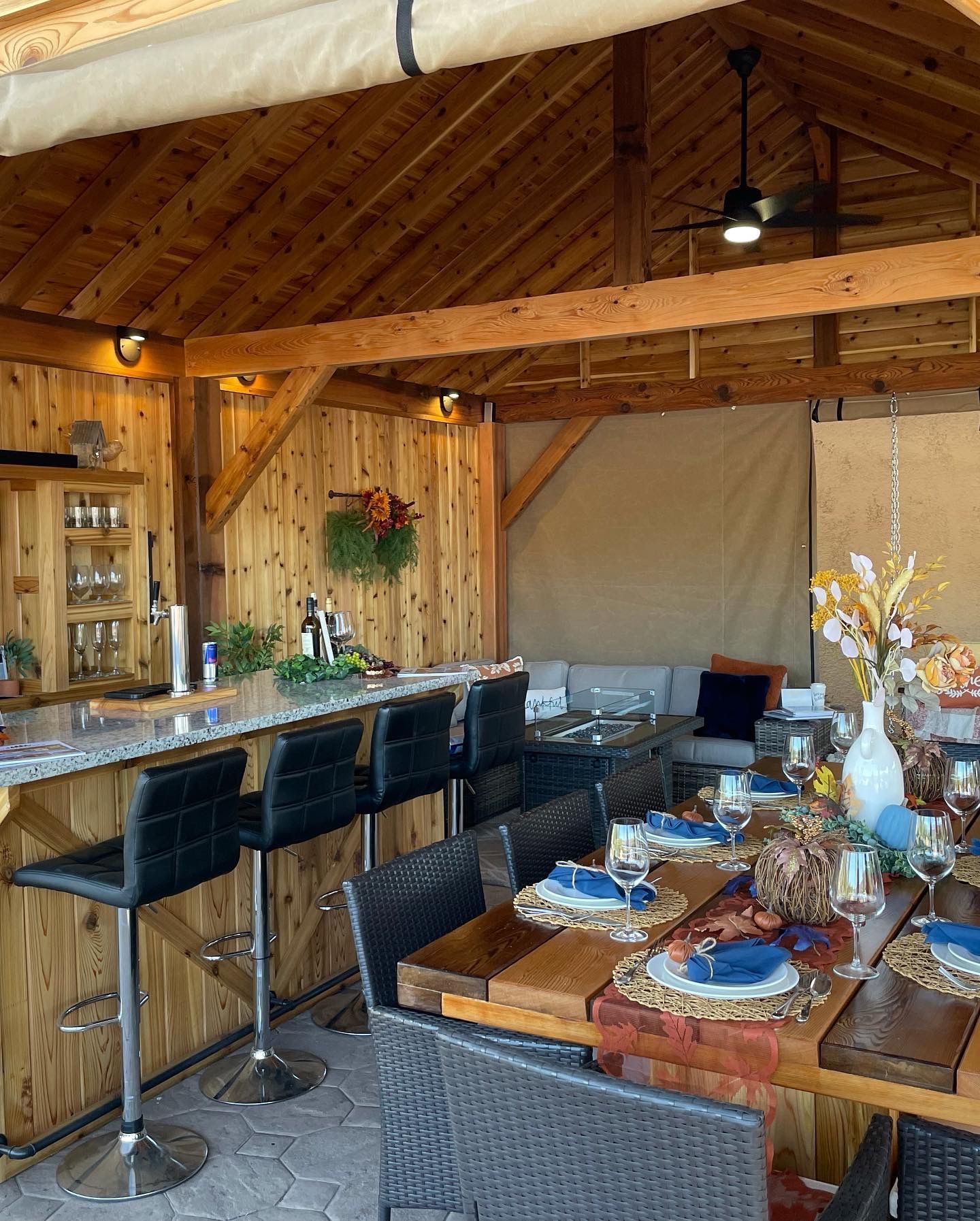 A dining room with tables and chairs and a bar.