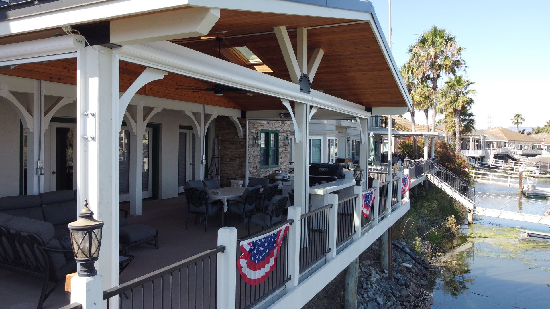 An aerial view of a house with a large porch overlooking a body of water.
