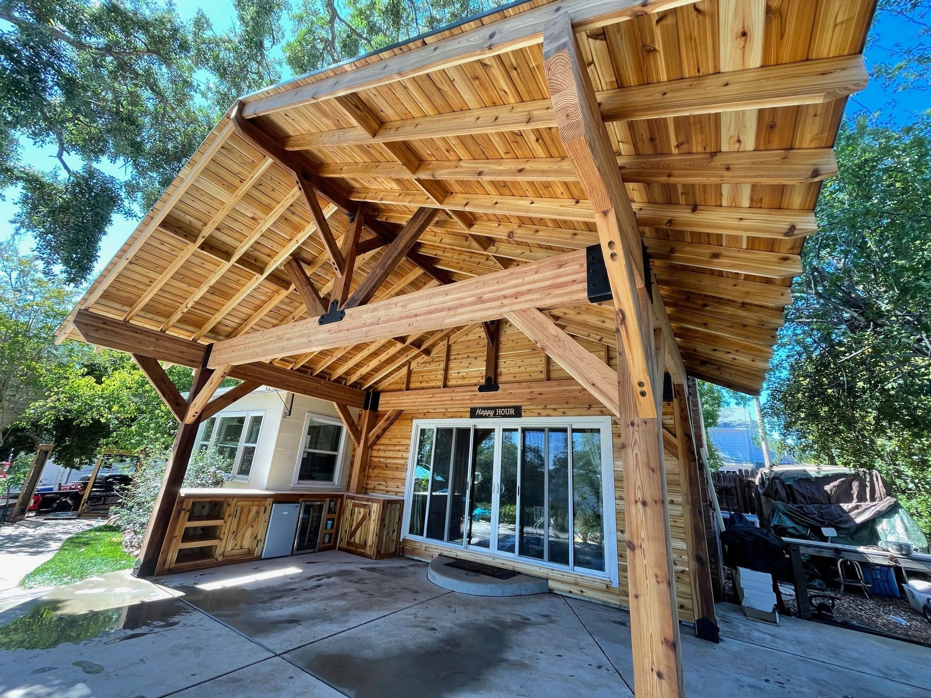A large wooden structure with a roof and a lot of windows.