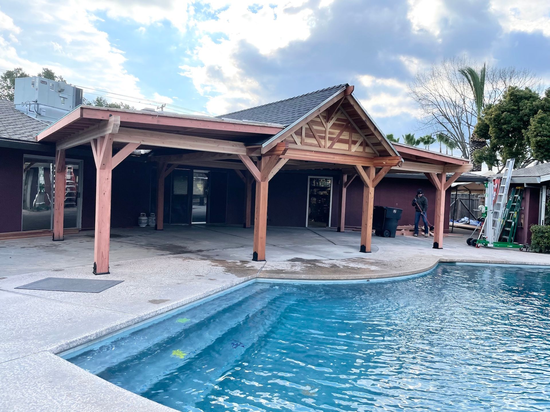 There is a large swimming pool in front of a house.