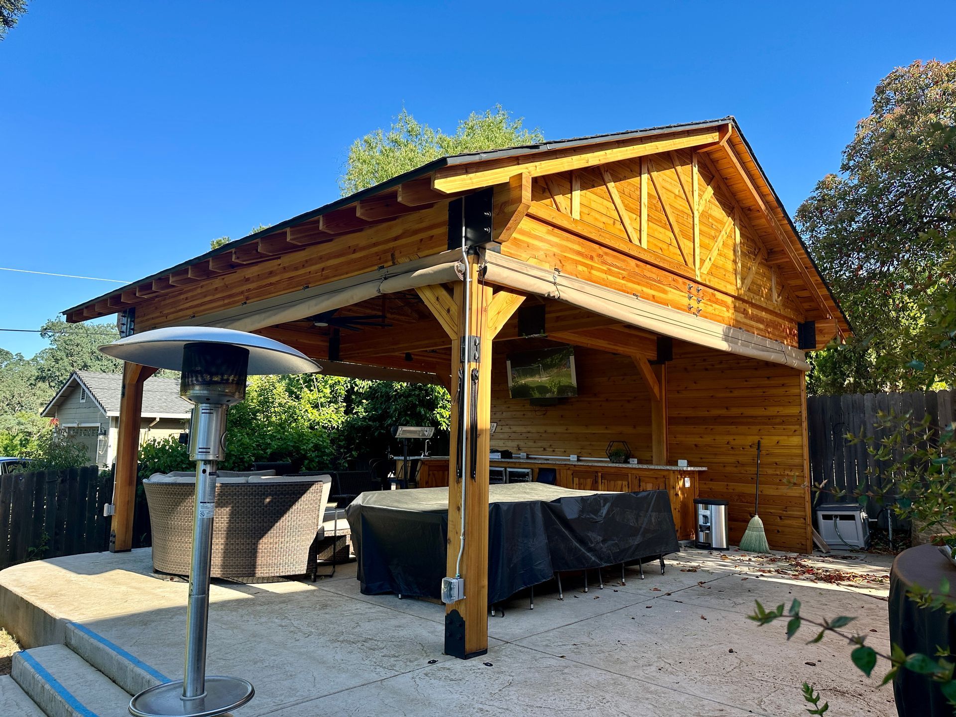 A wooden pavilion with a hot tub underneath it
