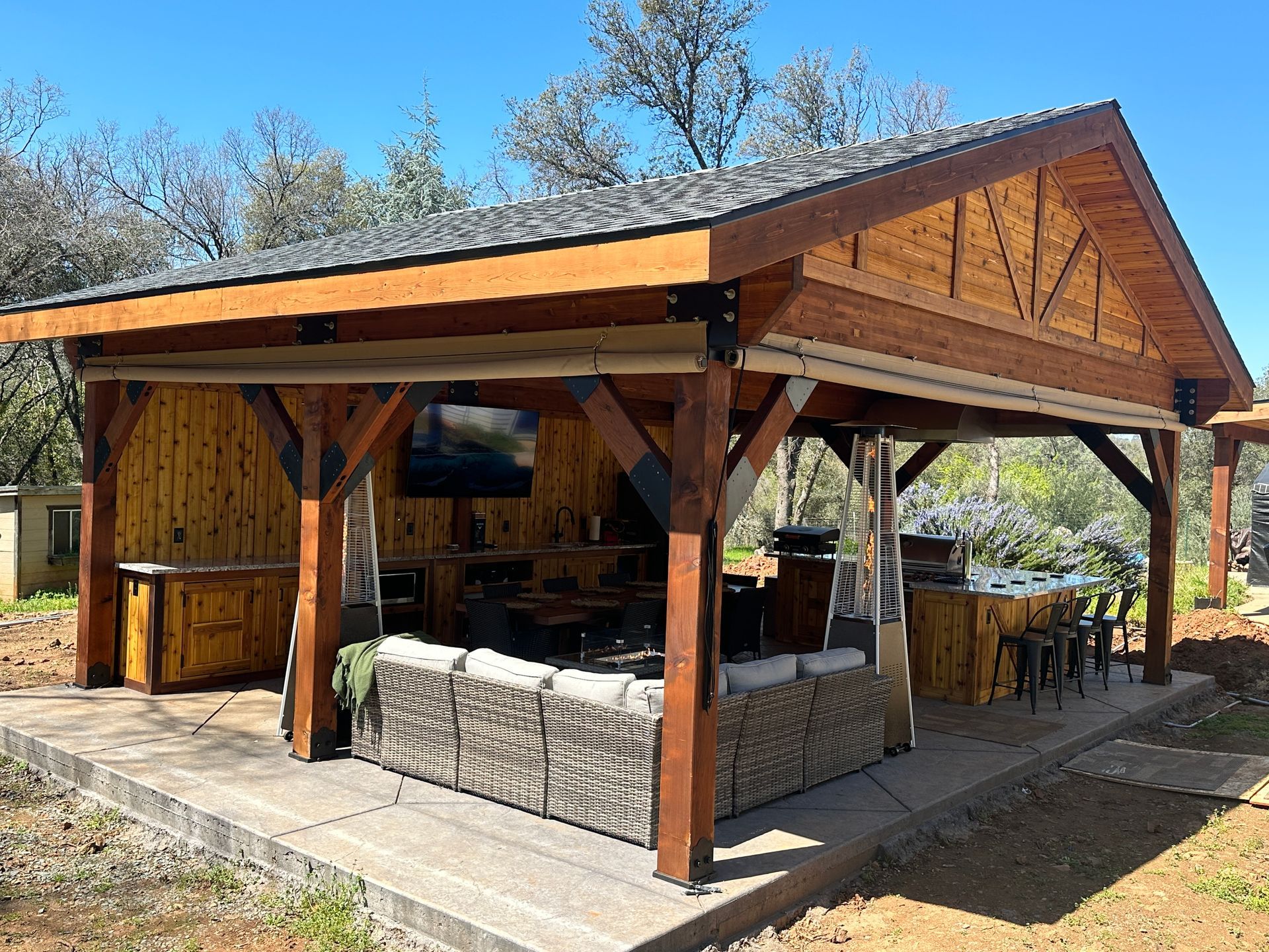 A wooden pavilion with a couch and a table underneath it.