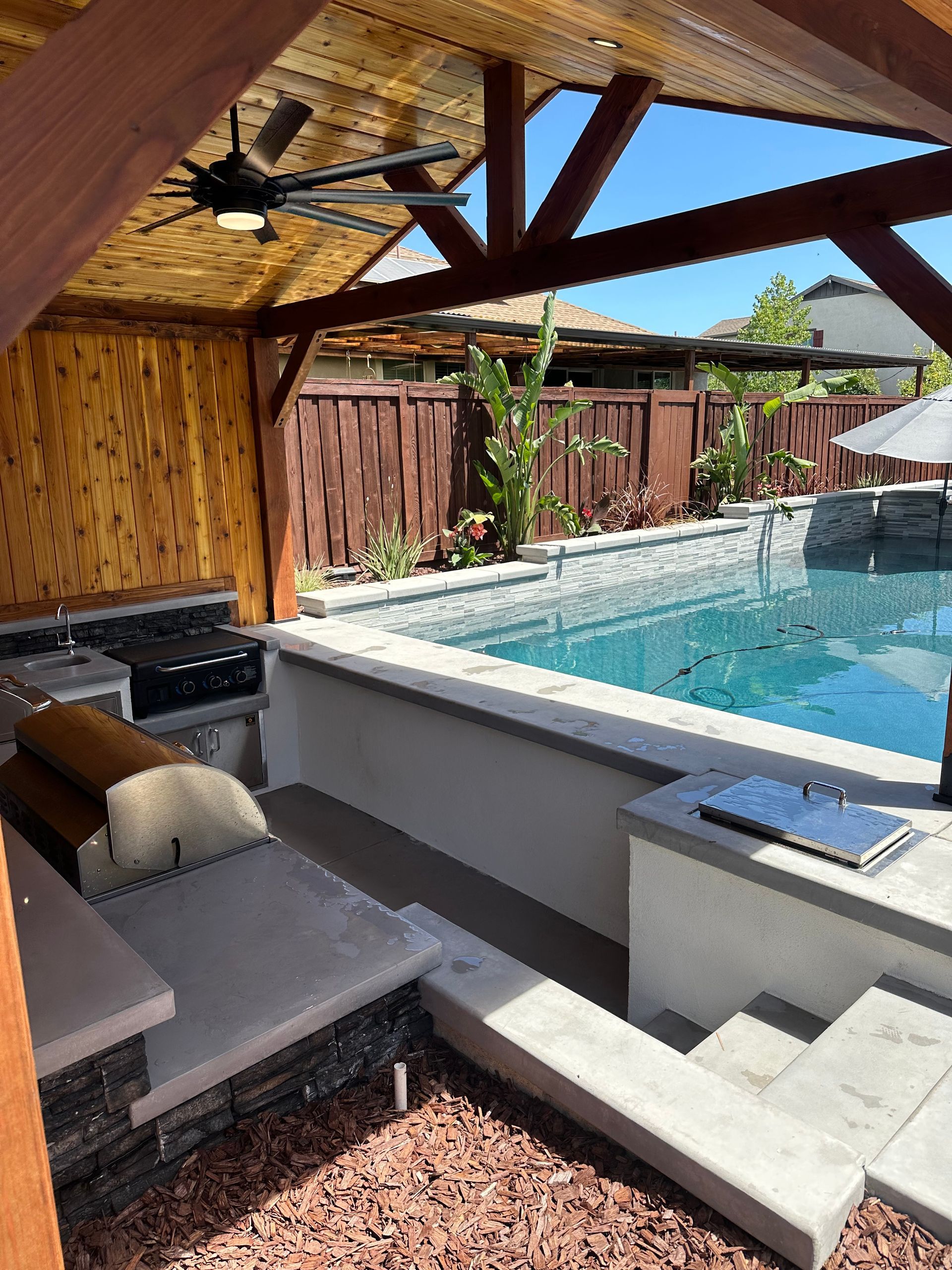 There is a large swimming pool in the backyard with a pavilion.