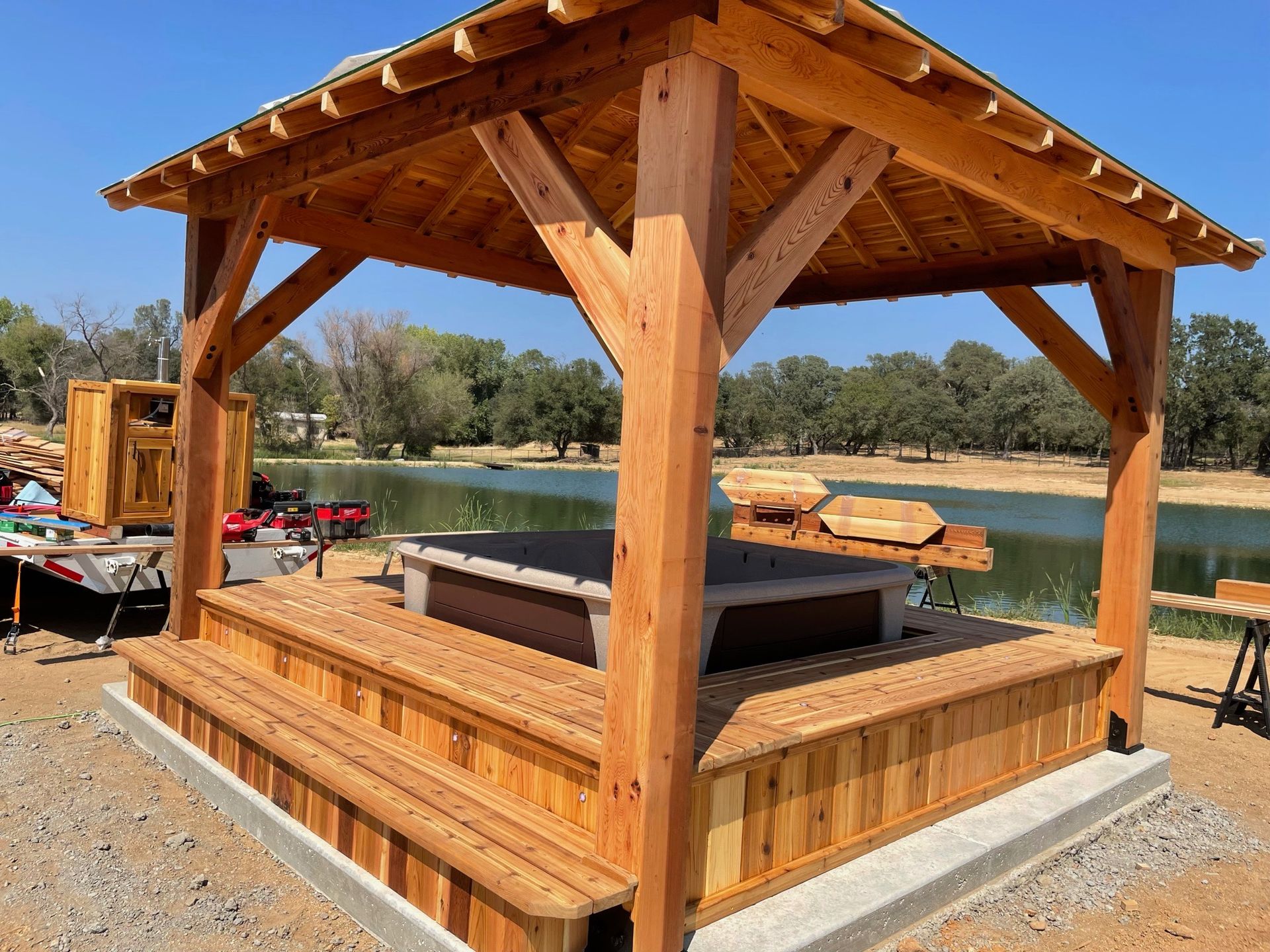 A wooden pavilion with a hot tub inside of it