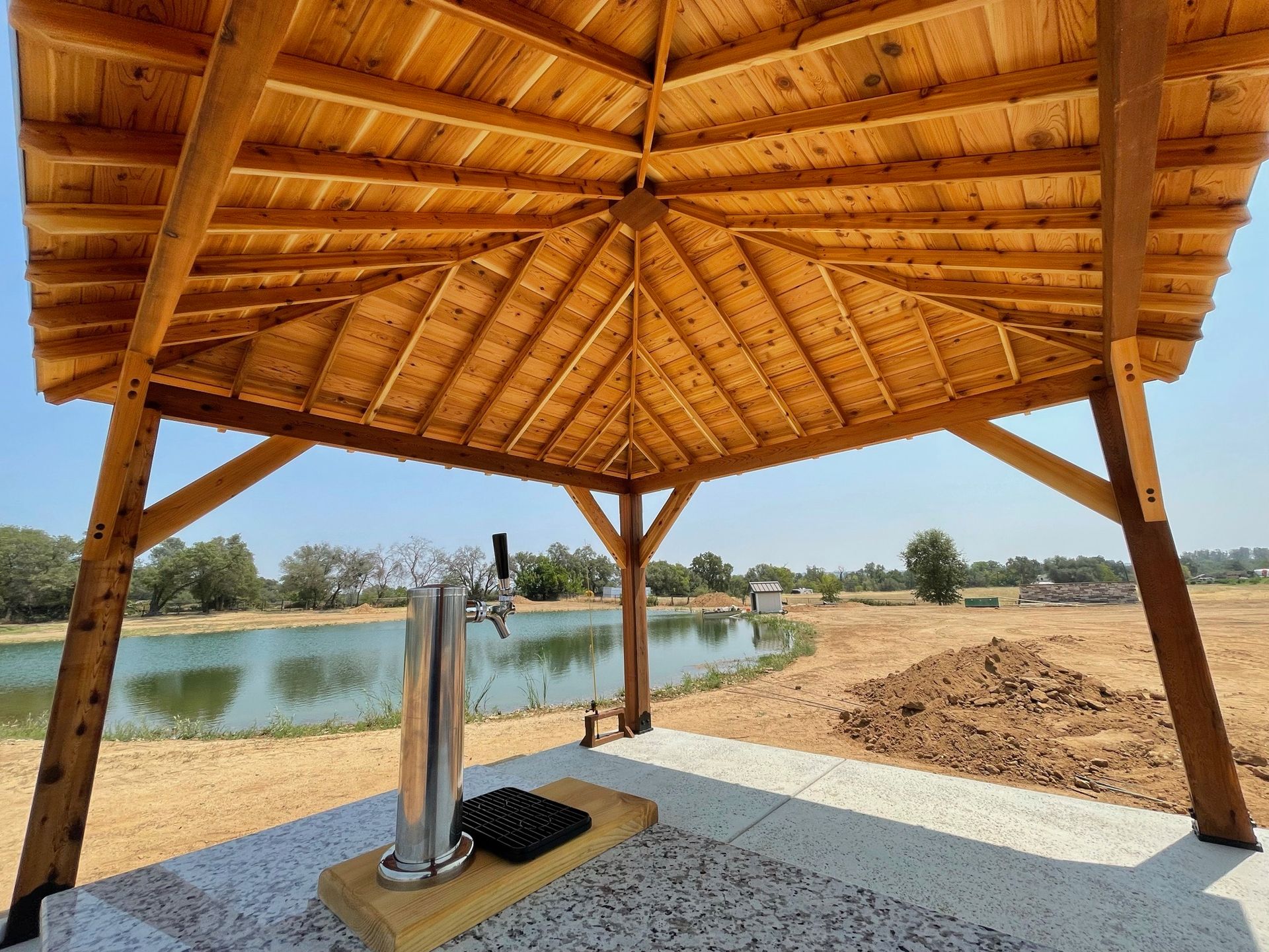 A wooden pavilion with a beer tap underneath it