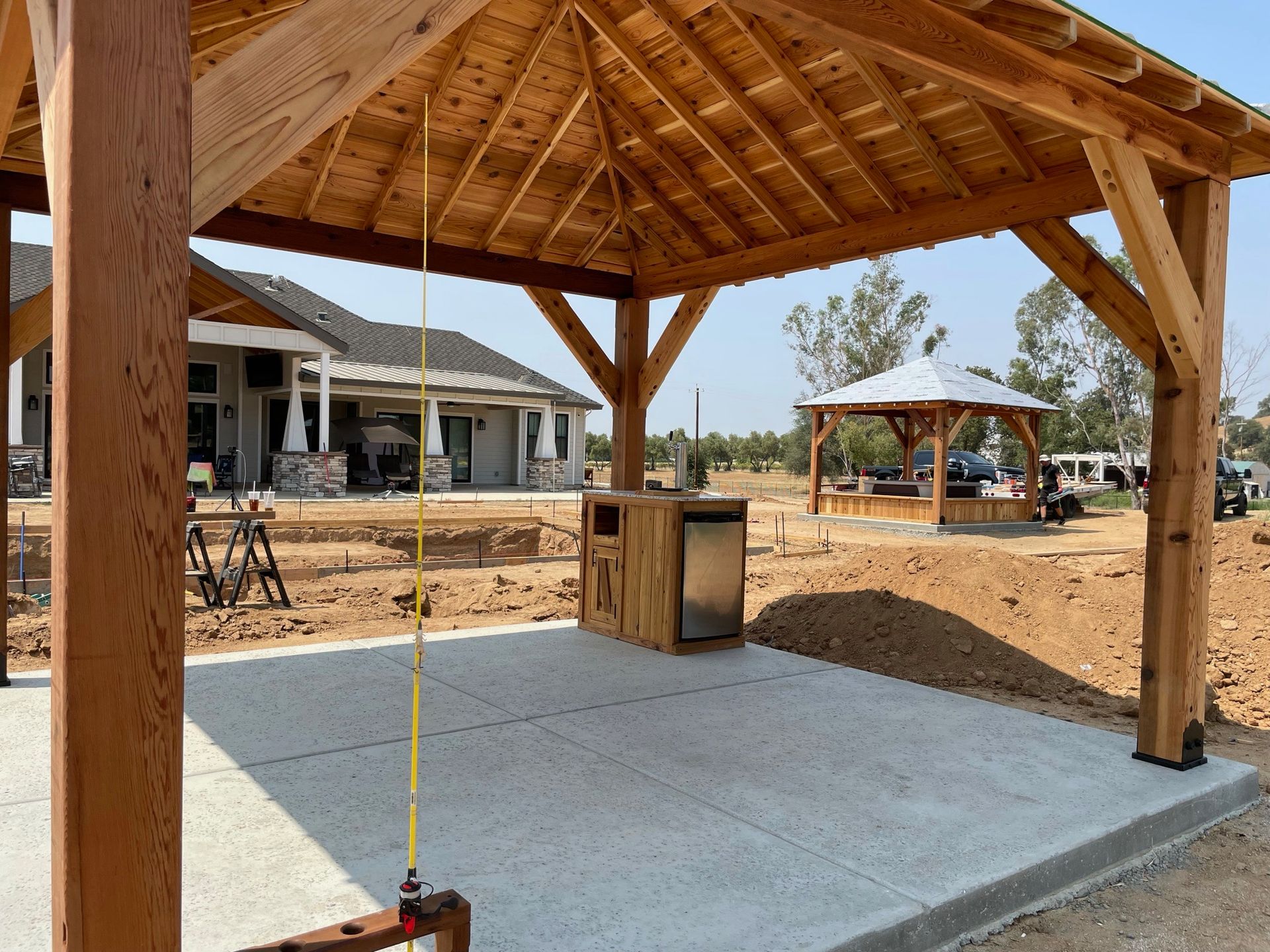 A wooden pavilion is being built in front of a house.