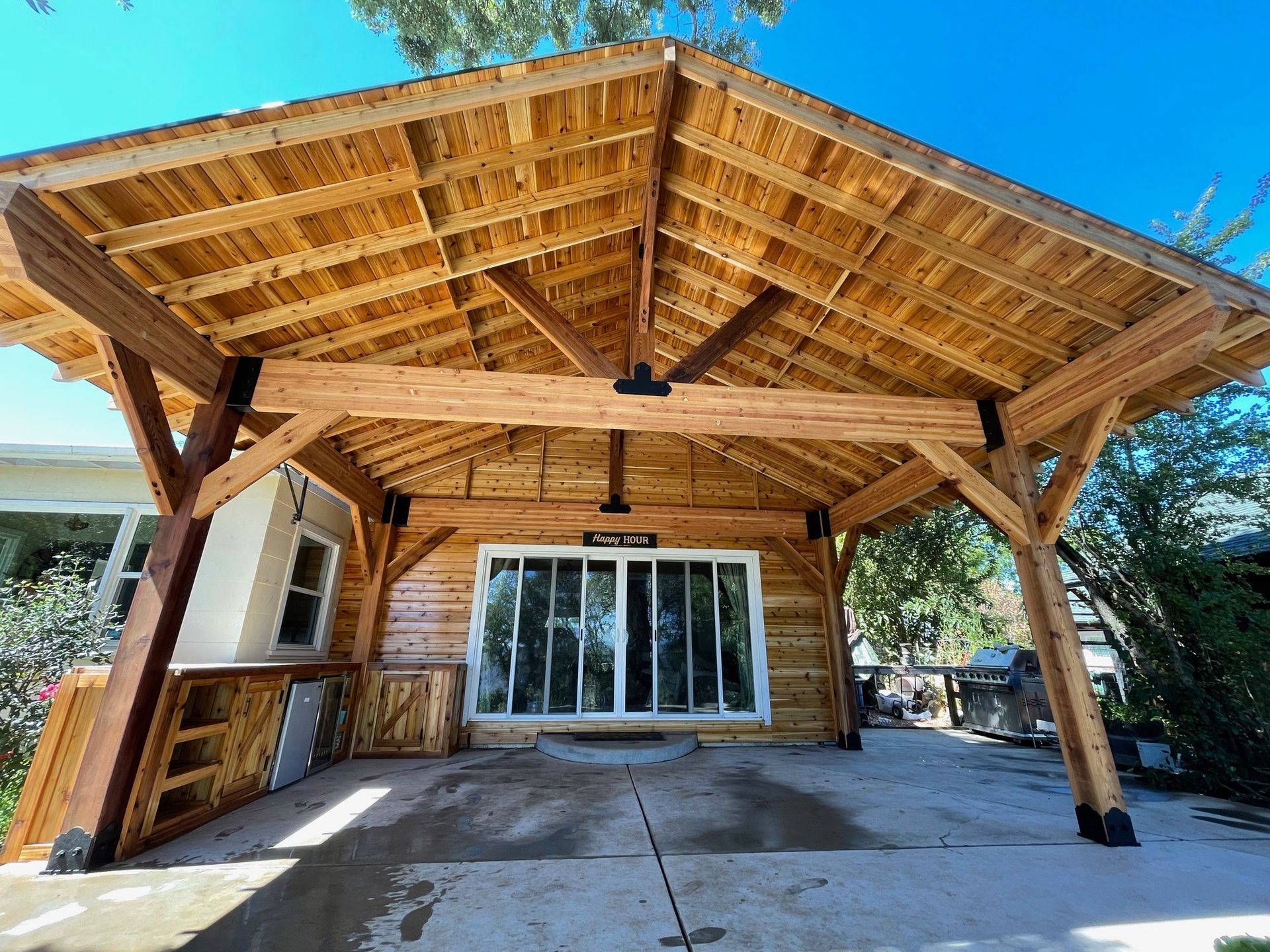 A wooden structure with a roof and a sliding glass door.