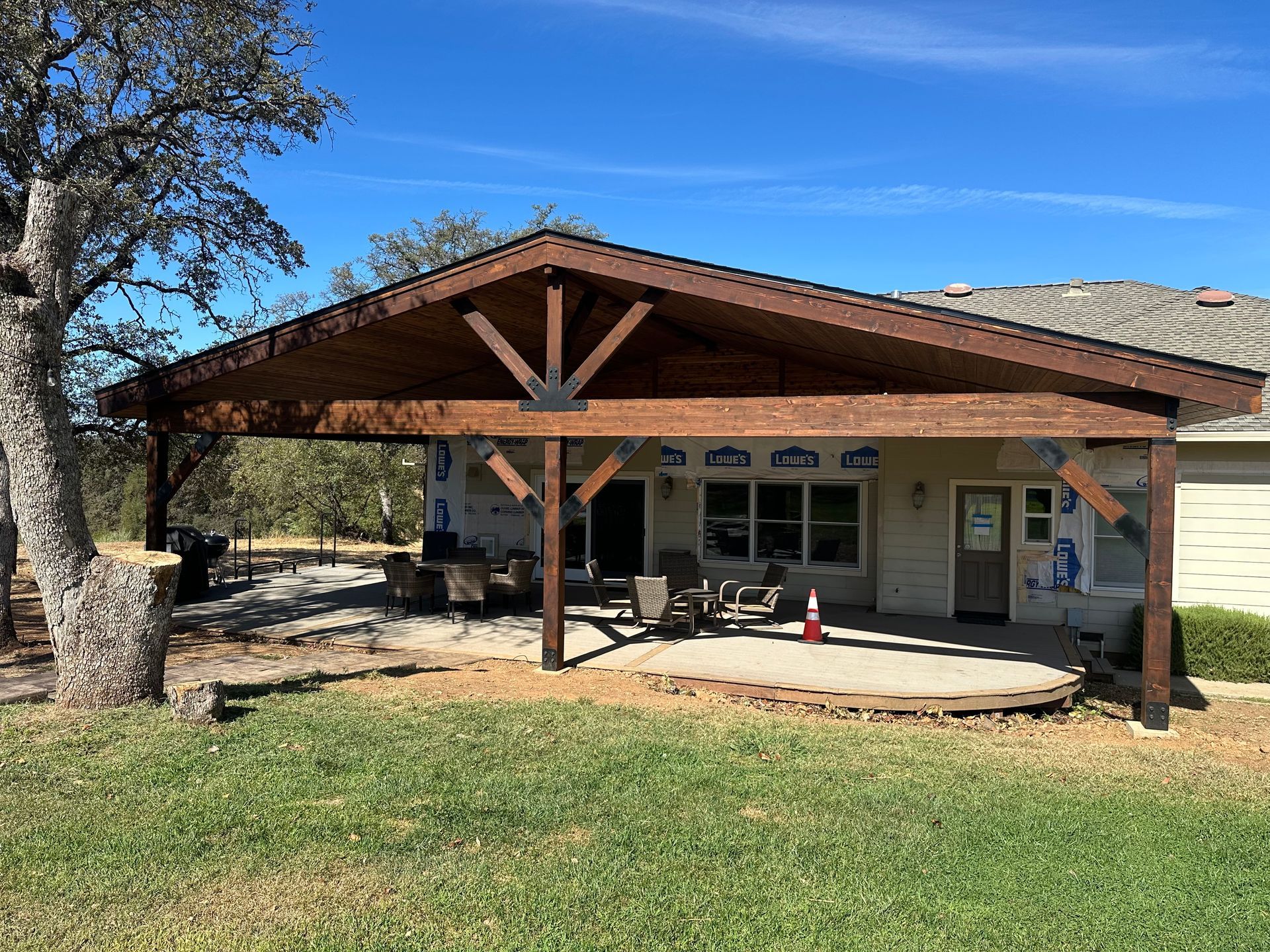 A house with a large wooden covered patio in front of it.