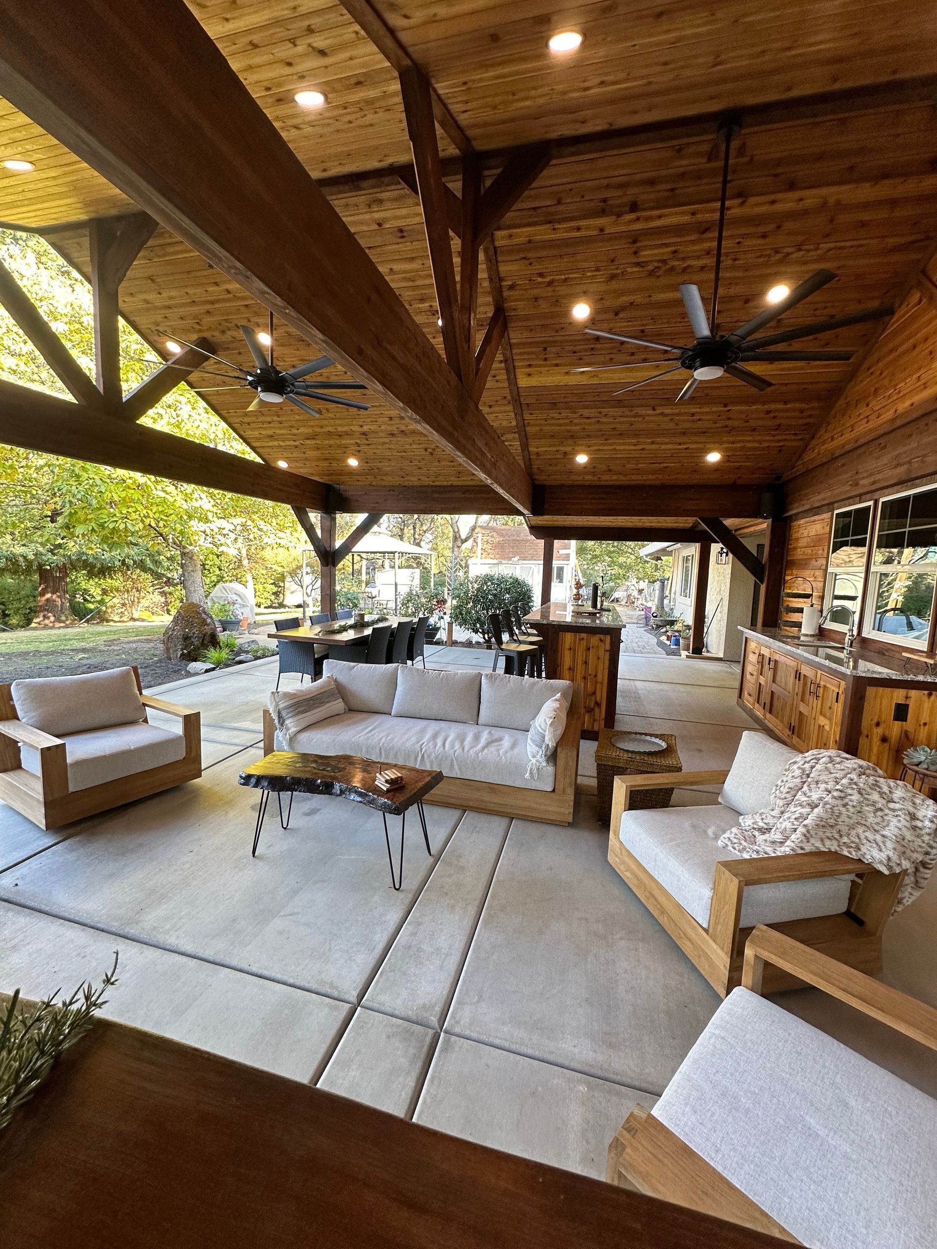 A living room with a couch , chairs , a table and a ceiling fan.