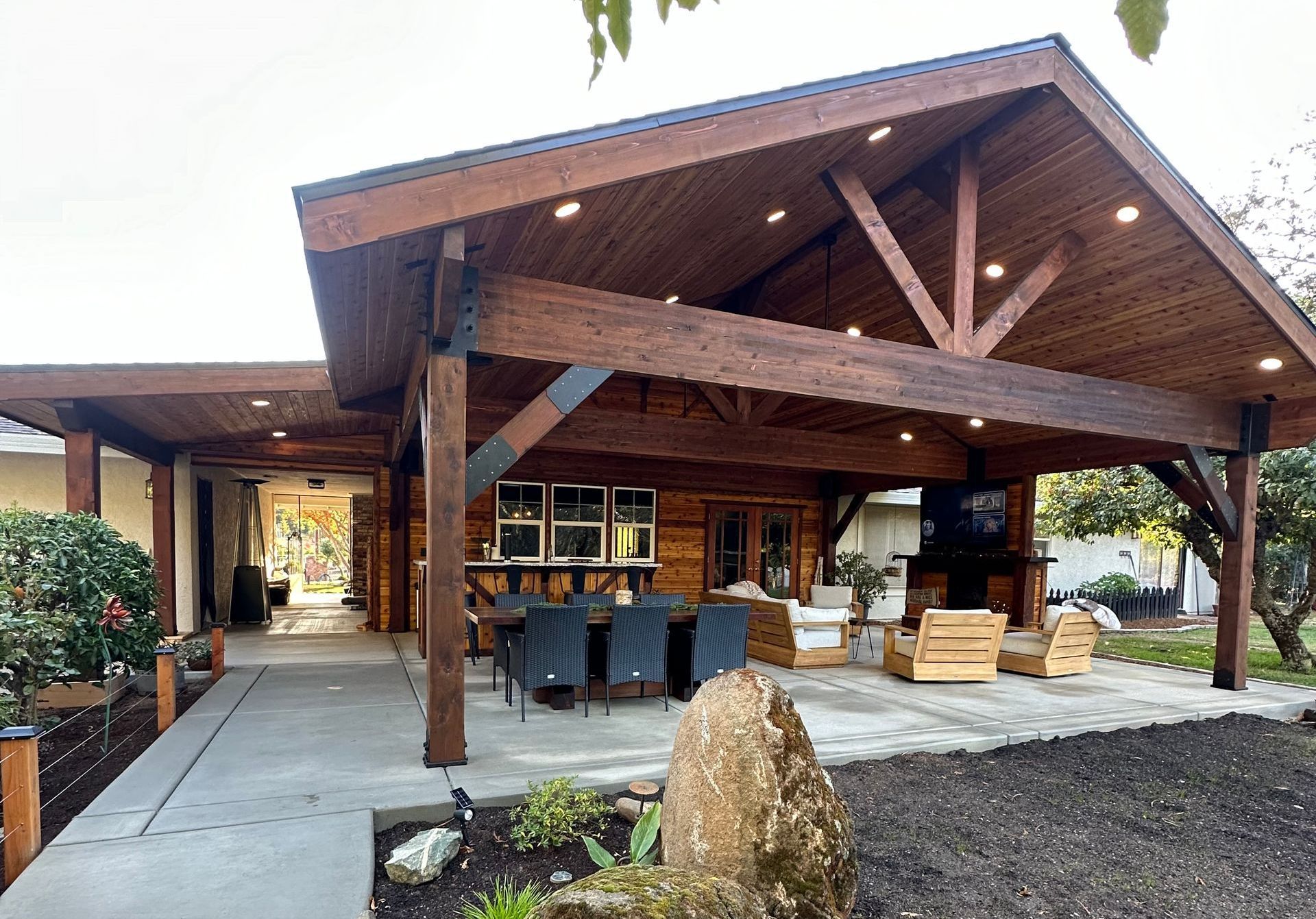 A large house with a wooden roof and a covered patio.