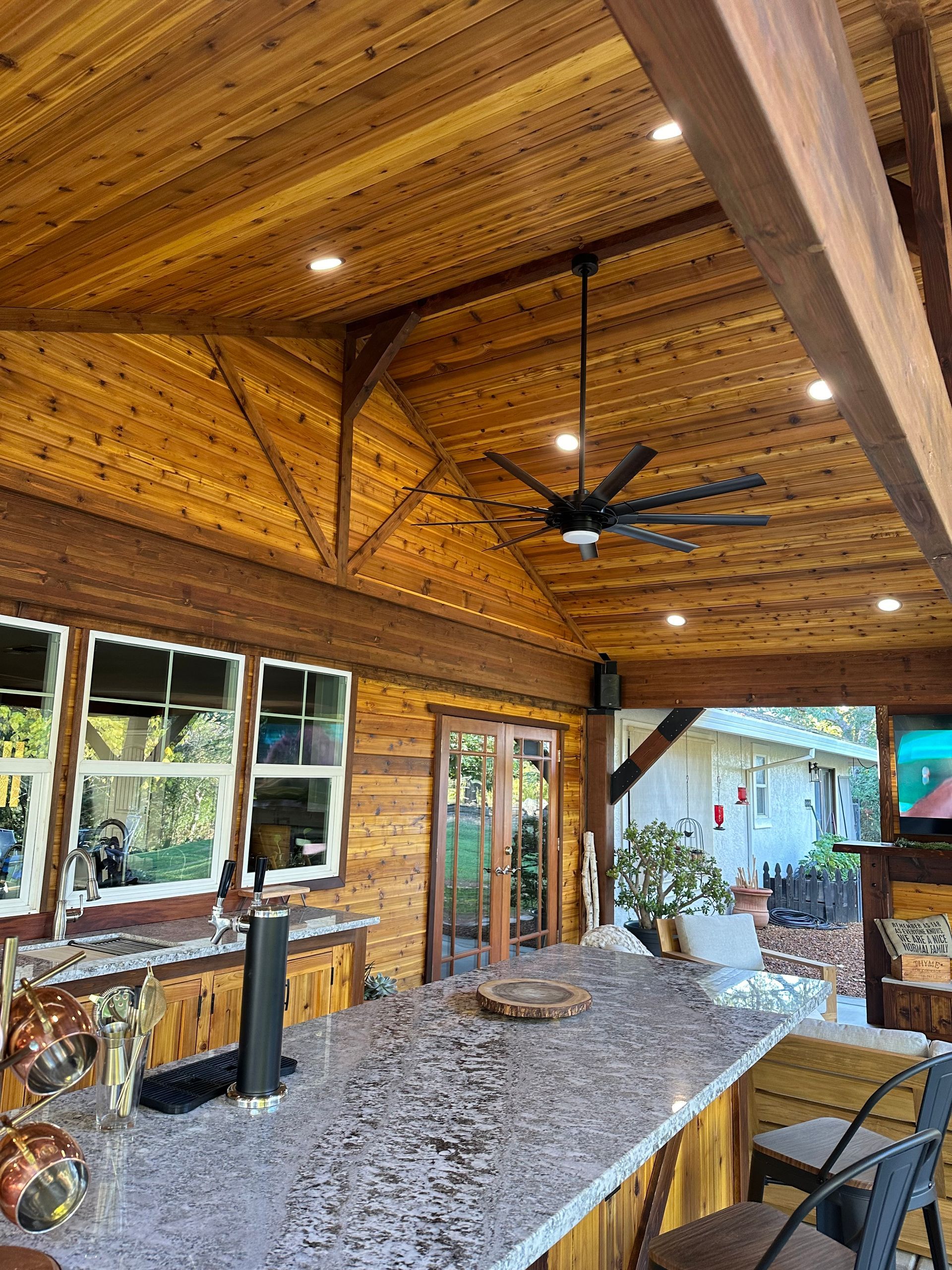 A kitchen with a large counter top and a ceiling fan.