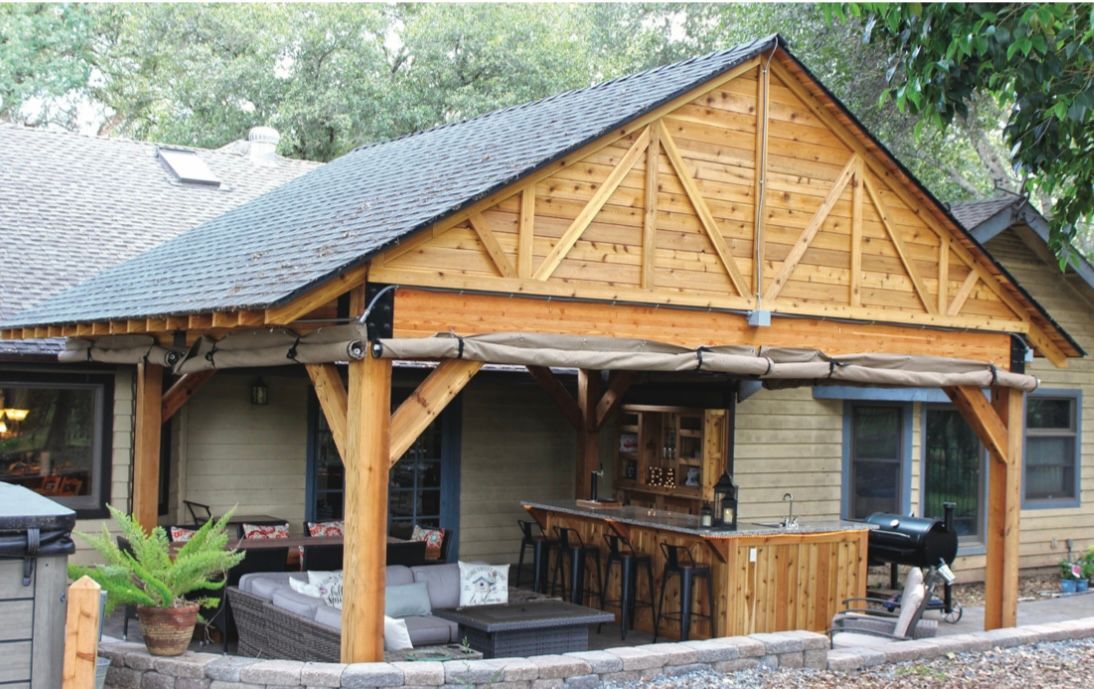 A house with a wooden porch and a bar underneath it.