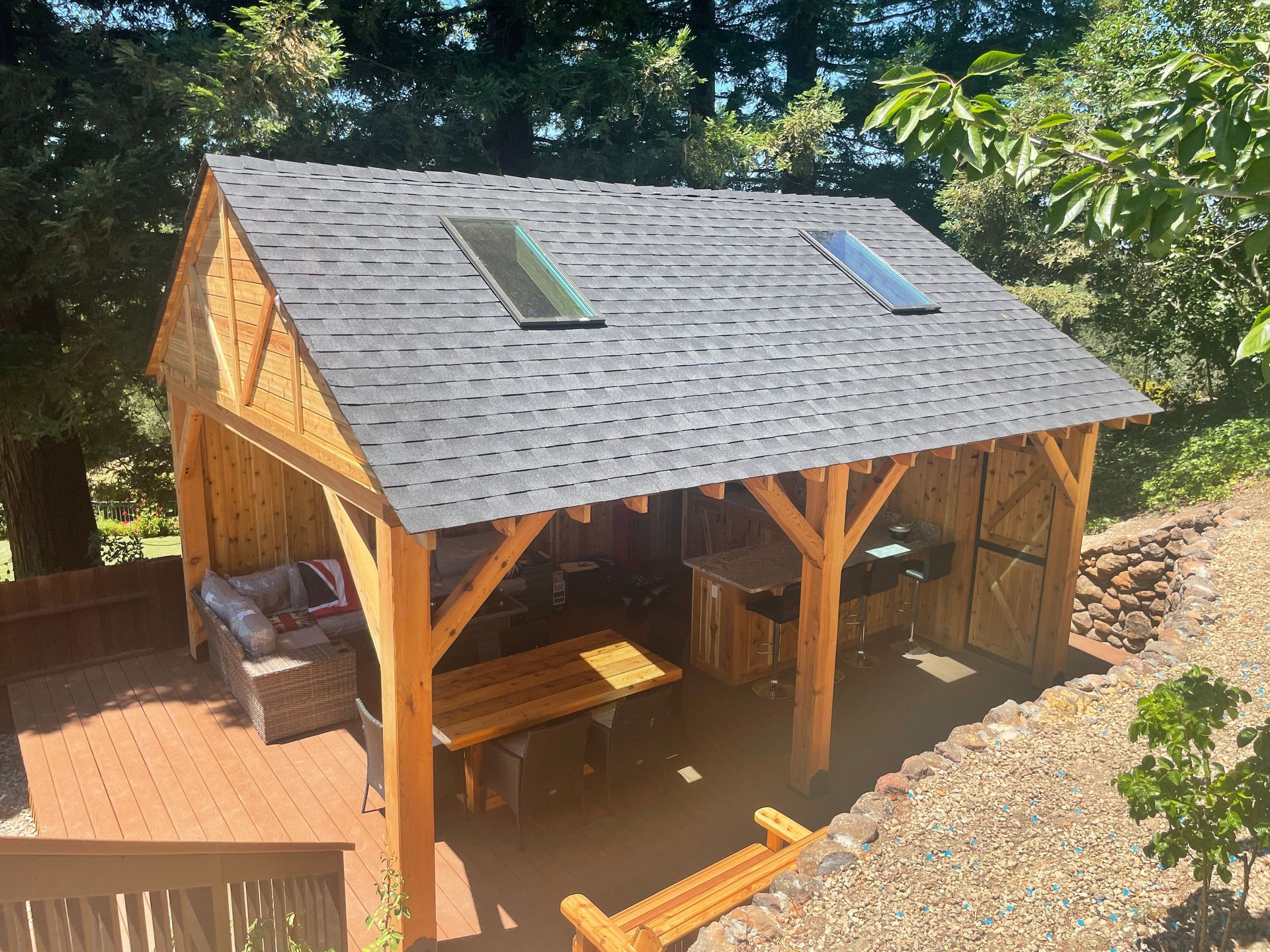 A wooden pavilion with a roof that has two skylights on it