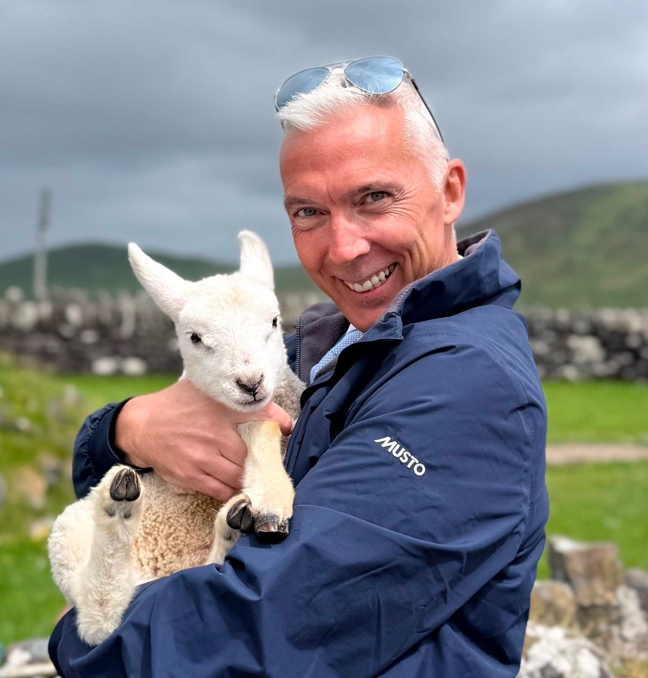 Owner of Evergreen Private Tours, Derek O'Keeffe holding a baby lamb