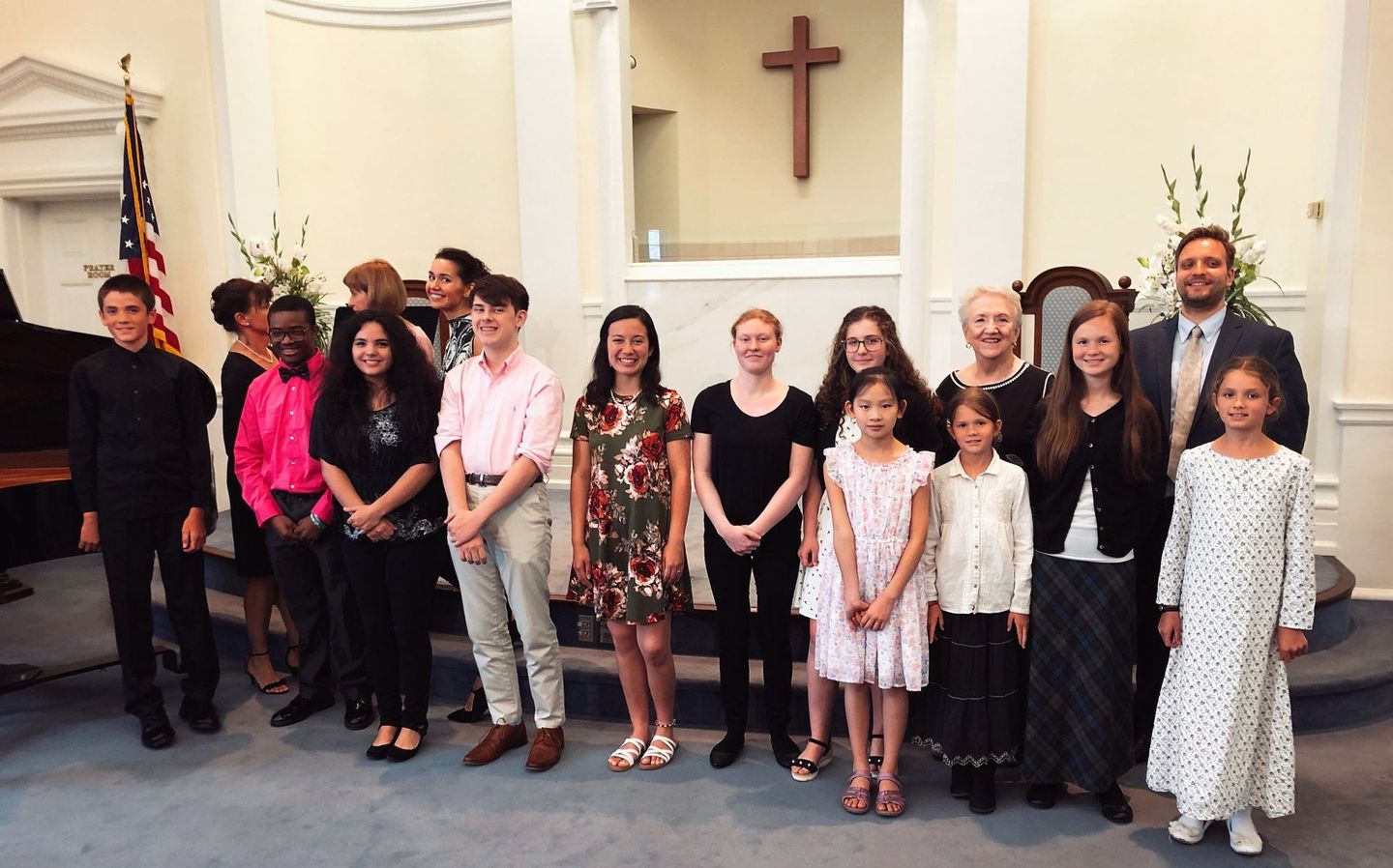 A group of people standing in front of a cross in a church