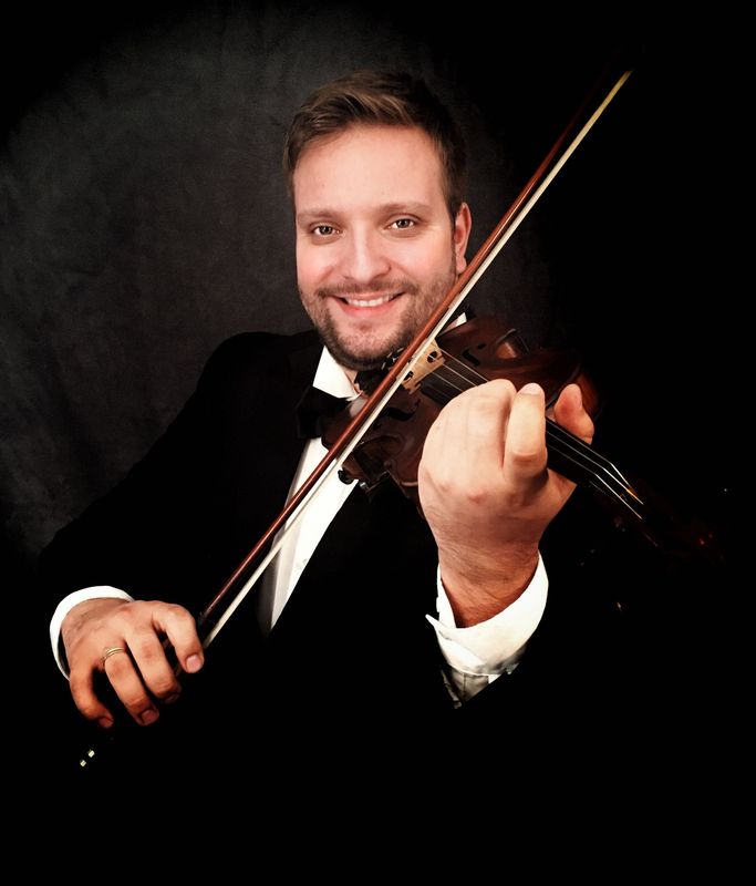 A man in a tuxedo is playing a violin