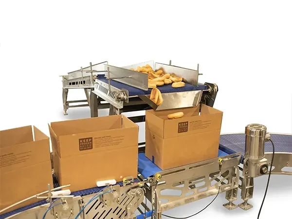 Industrial lift with a stainless steel bin tilted upward, in a white setting.