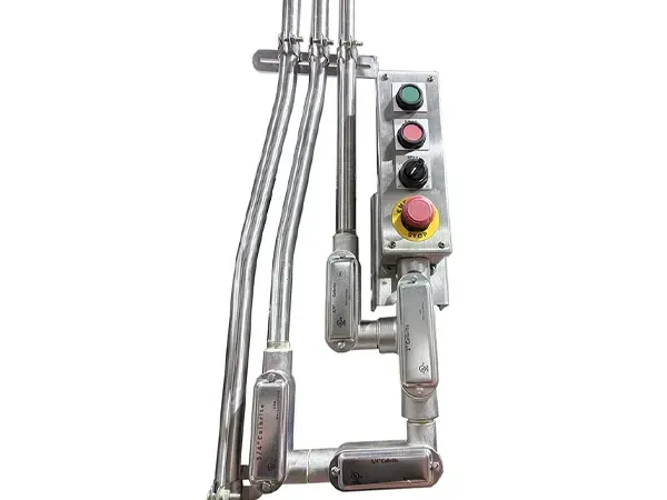 Control panel with green, red, and yellow buttons, likely for industrial equipment, mounted on metal tubing.