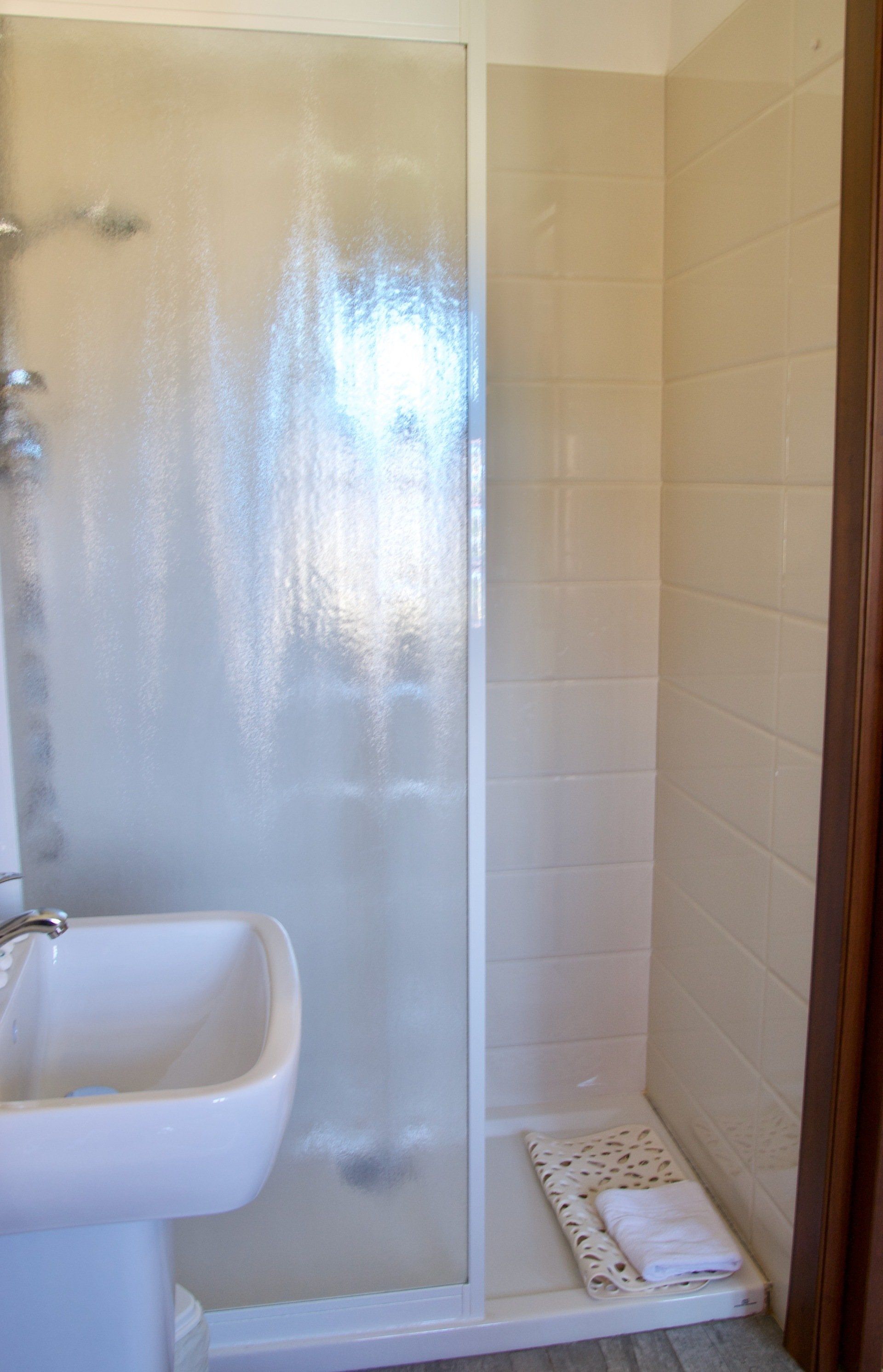 Un bagno con lavandino e cabina doccia.