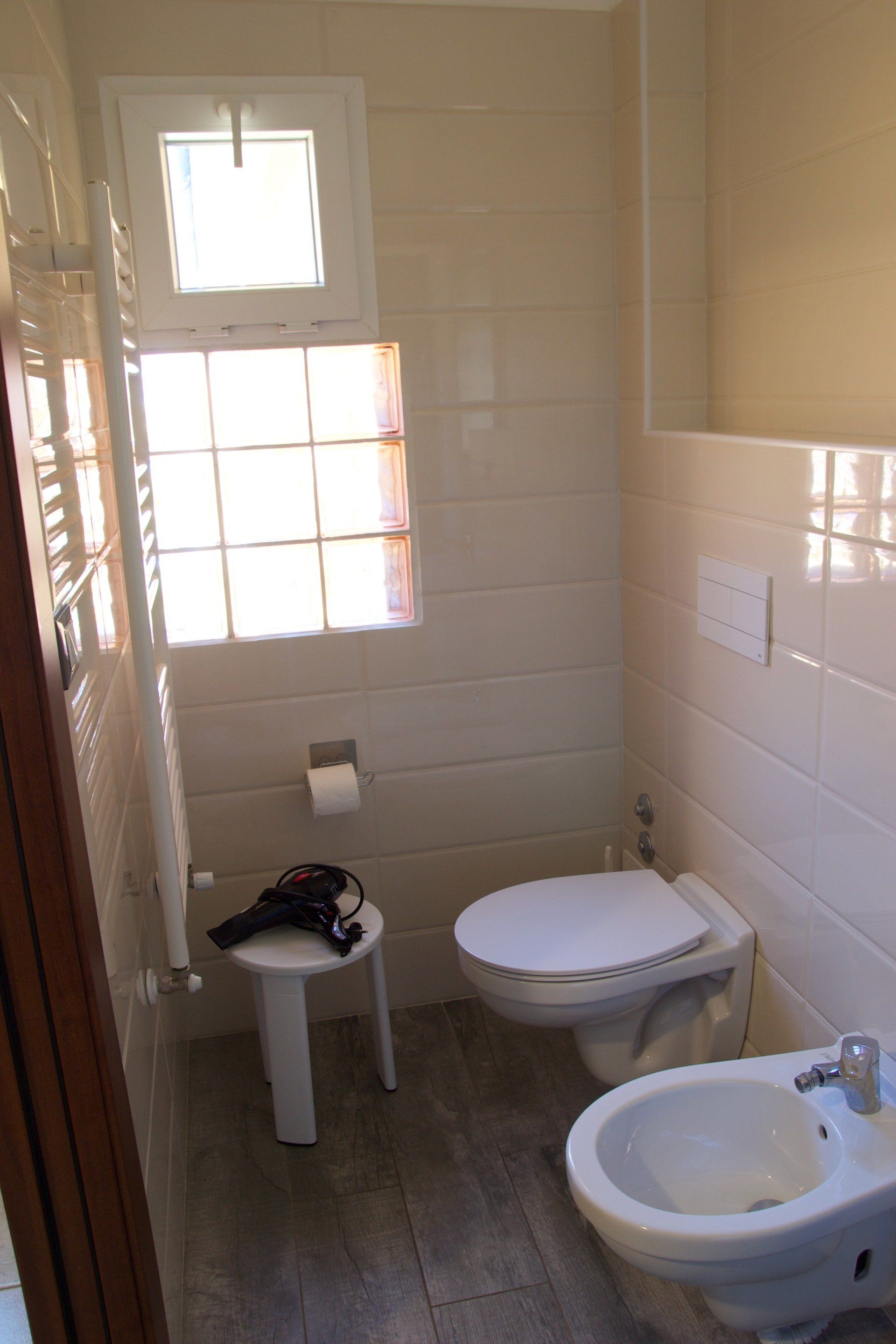 Un bagno con due wc, un bidet e una finestra in un albergo con ristorante a Bologna