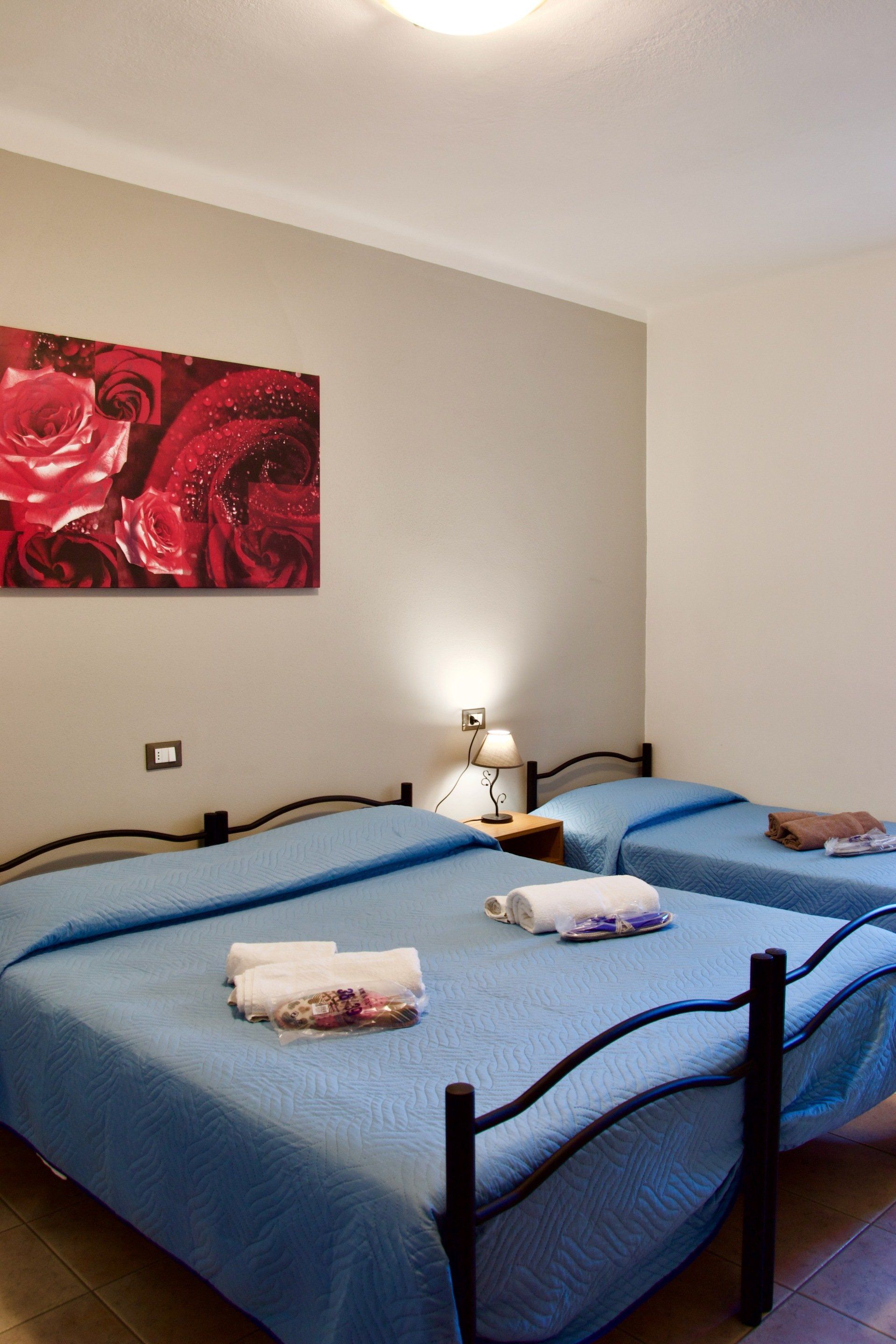 Una camera da letto con due letti e un quadro sul muro in un alloggio con ristorante vicino a Bologna