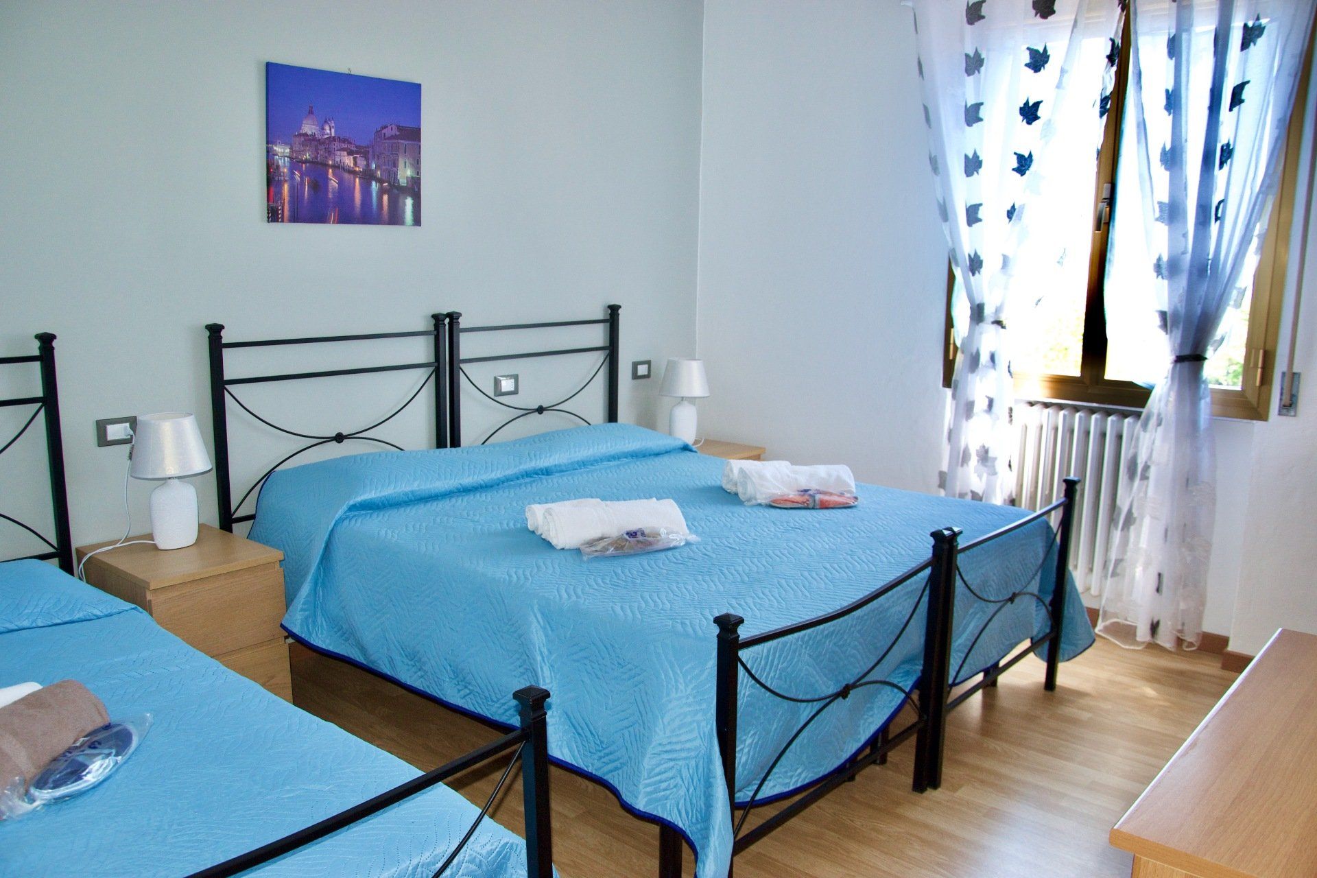 Una camera da letto con due letti e un quadro sulla parete sopra il letto in un albergo con ristorante a Bologna