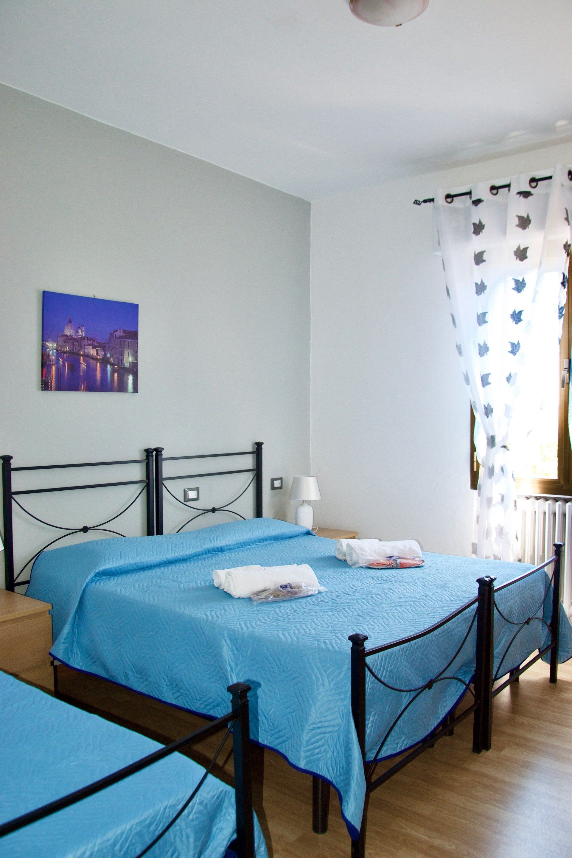 Una camera da letto con due letti e un quadro sul muro in un hotel con ristorante a Bologna