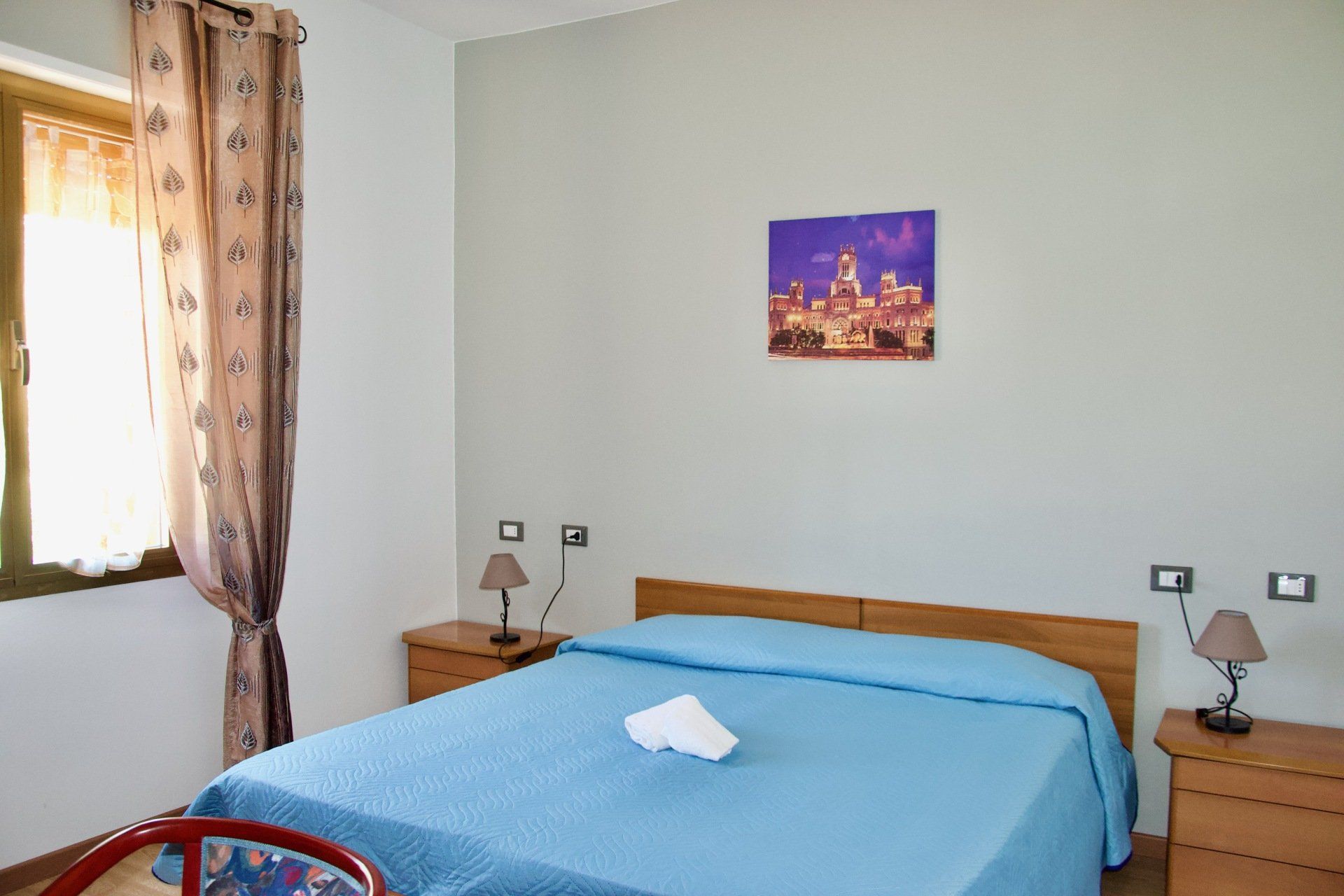 Una camera da letto con un letto e un quadro sul muro in un alloggio con ristorante a Bologna