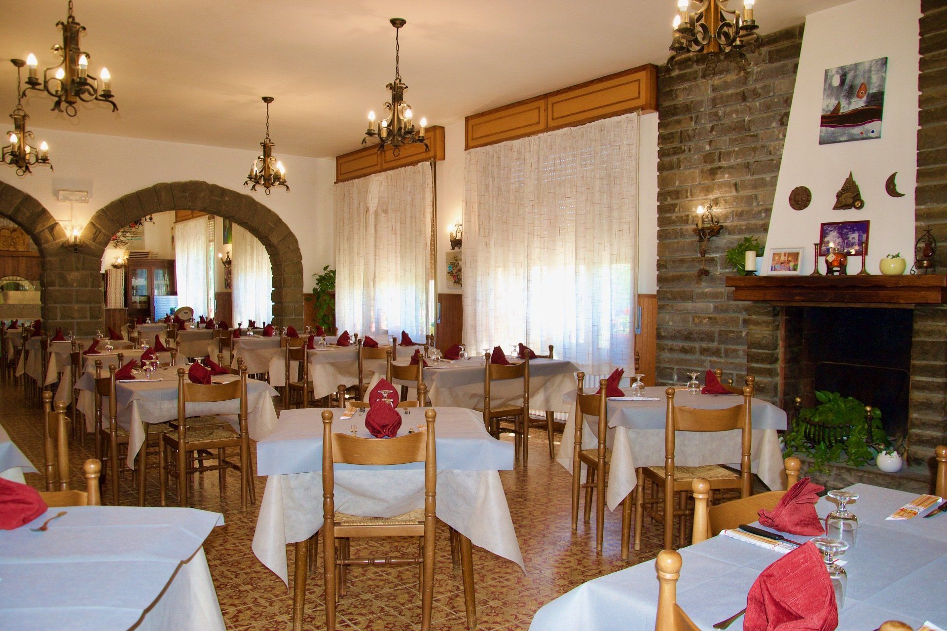 Un ristorante con tavoli, sedie e un camino
