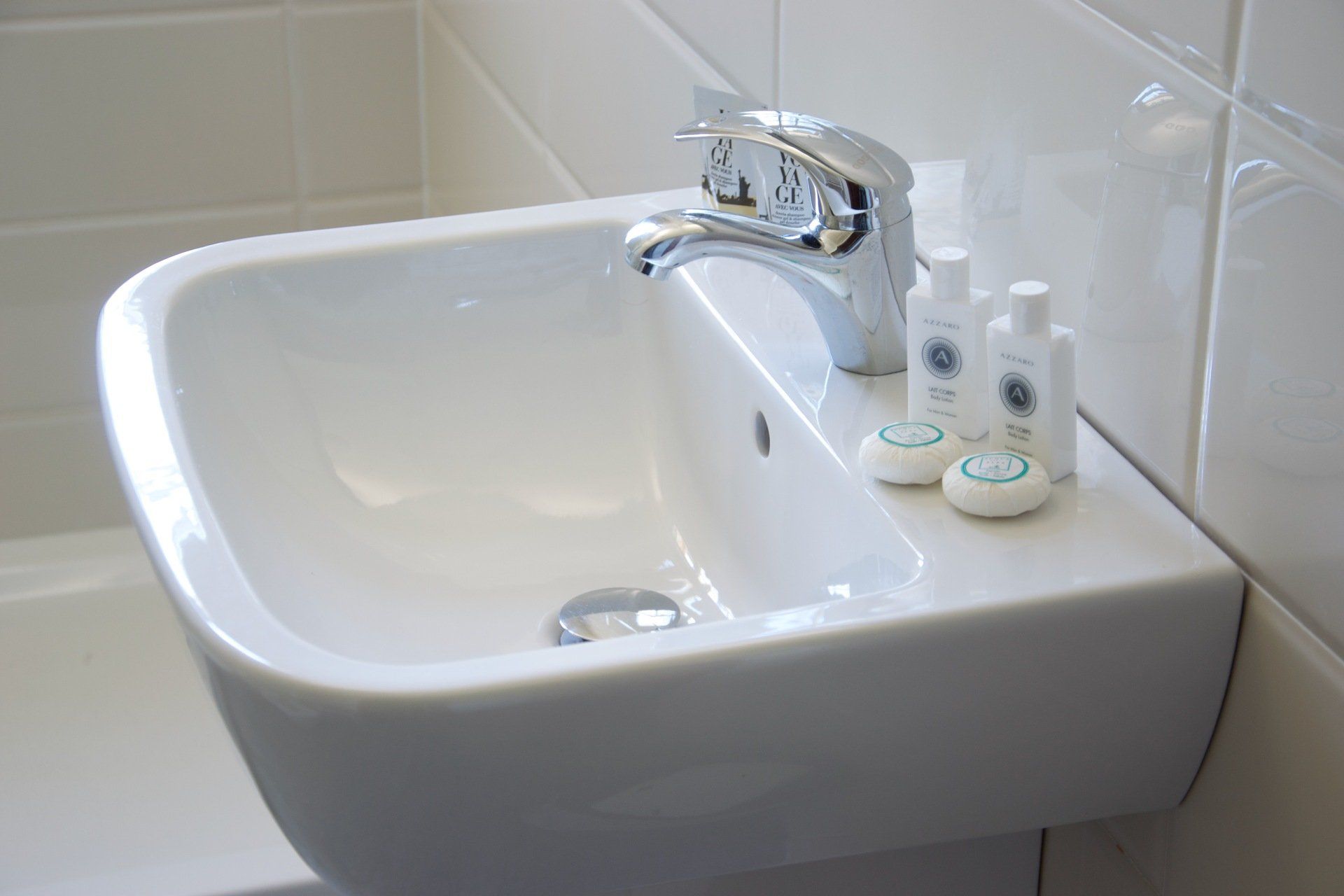 Un lavandino del bagno con saponi e lozioni sopra