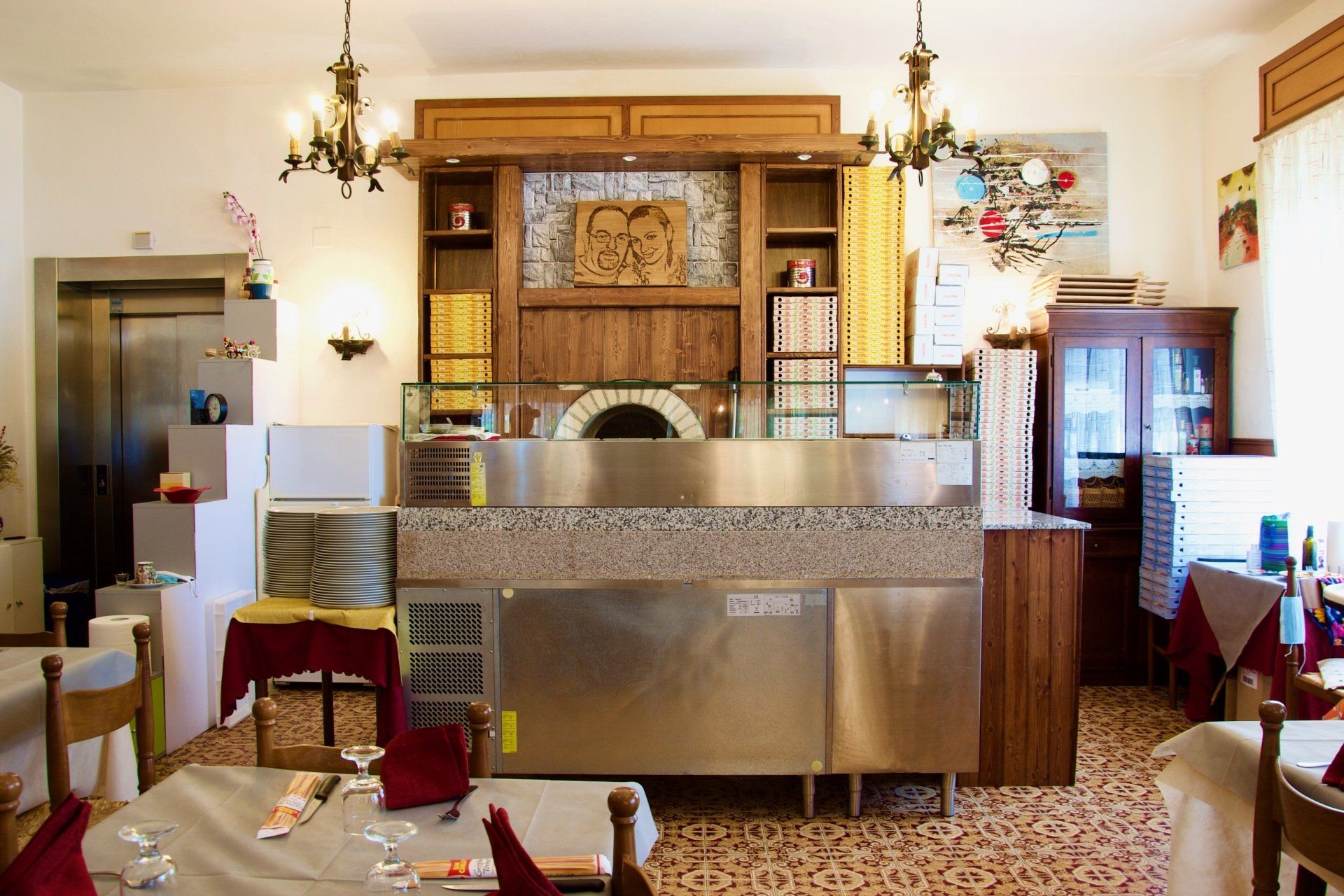 Un ristorante con tavoli e sedie e un forno per pizza