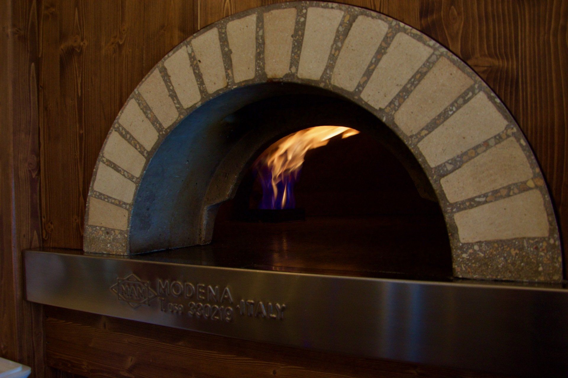 Un forno per pizza da cui esce una fiamma nel ristorante con funghi e tartufo a Bologna