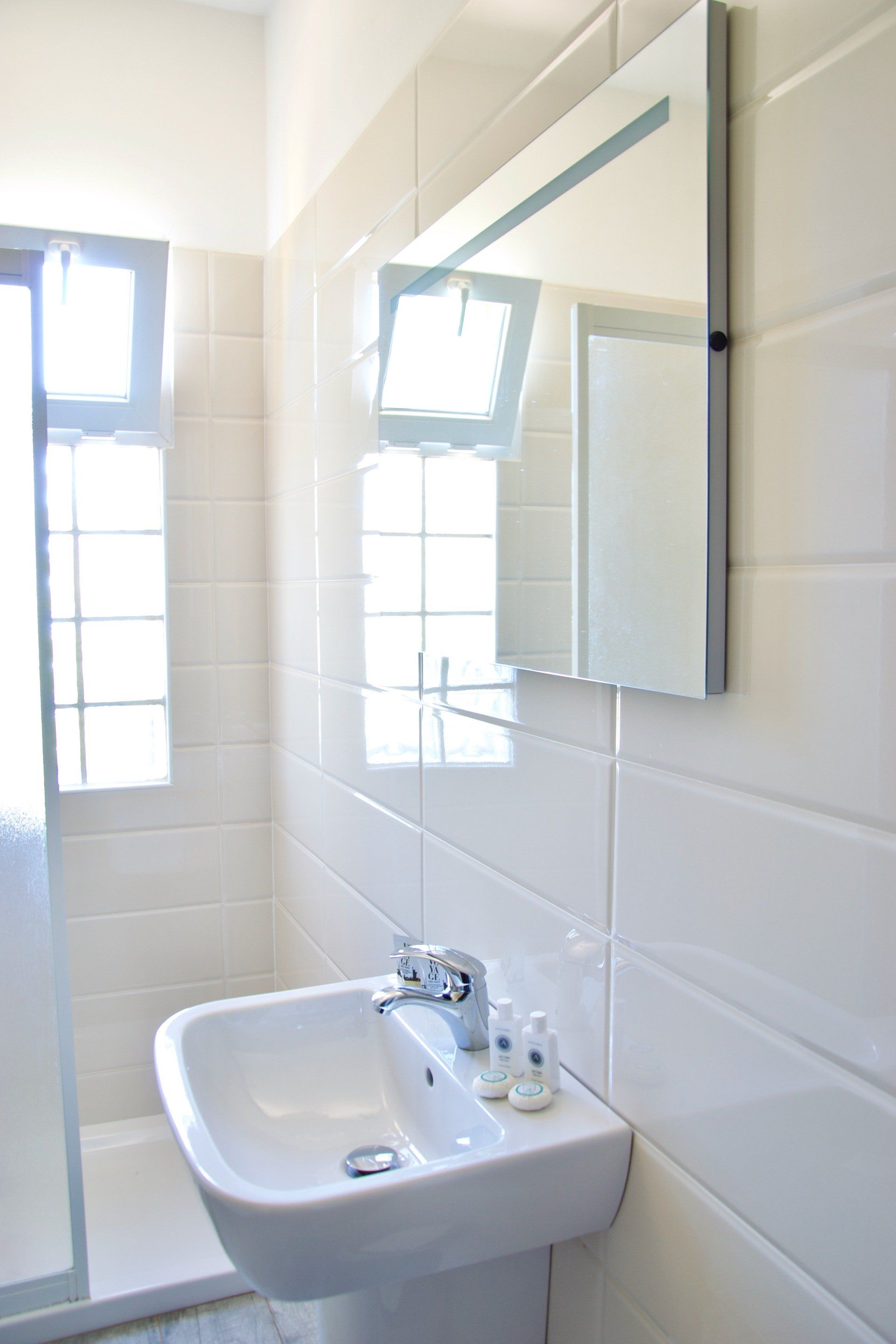 Un bagno con lavandino, specchio e doccia.