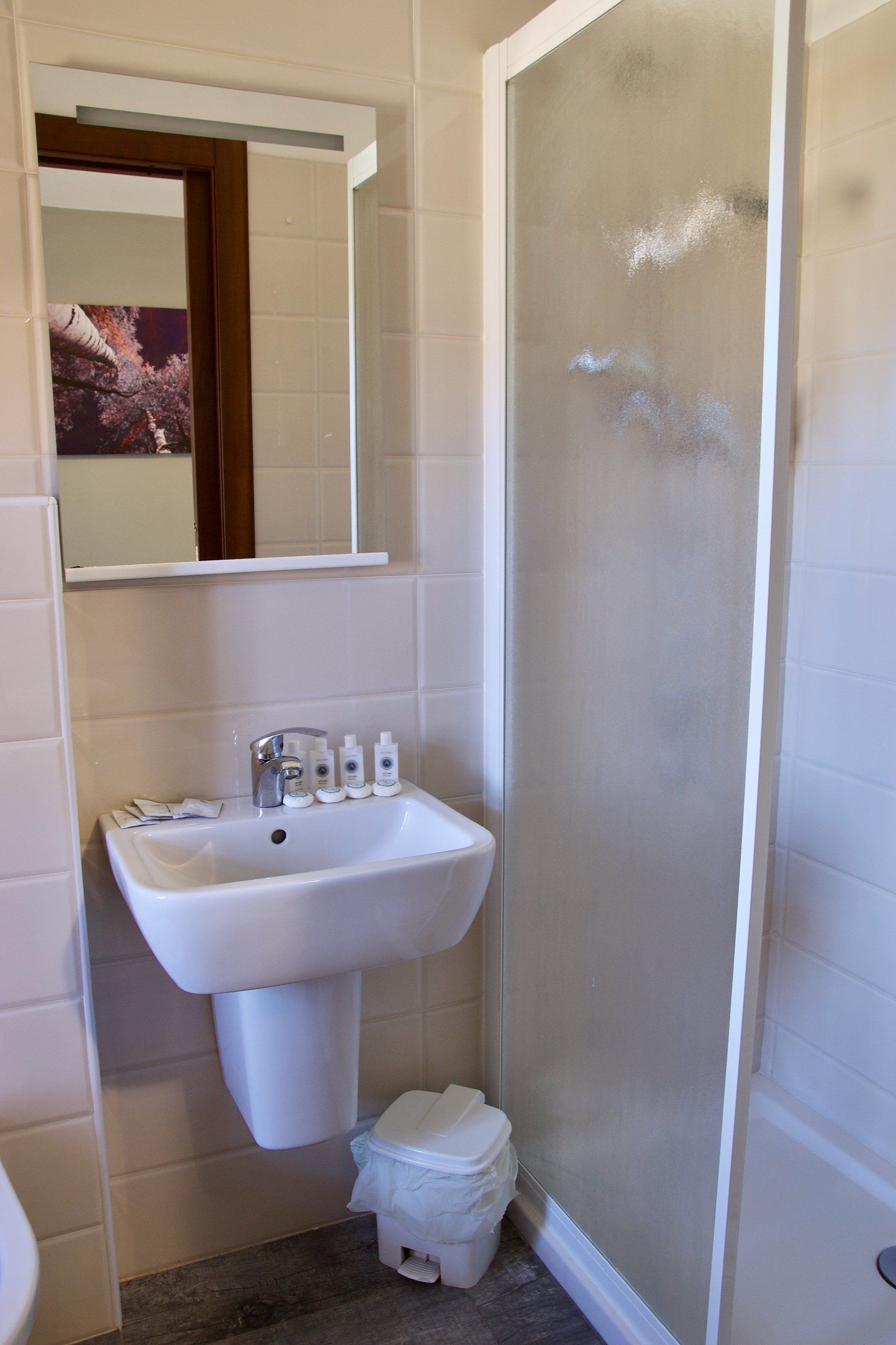 Un bagno con lavandino, WC e doccia.