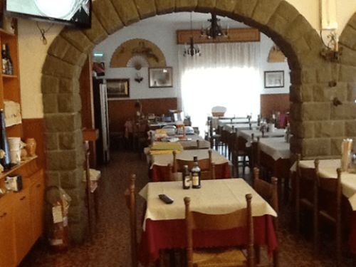 Un ristorante con tavoli e sedie e una tv a parete