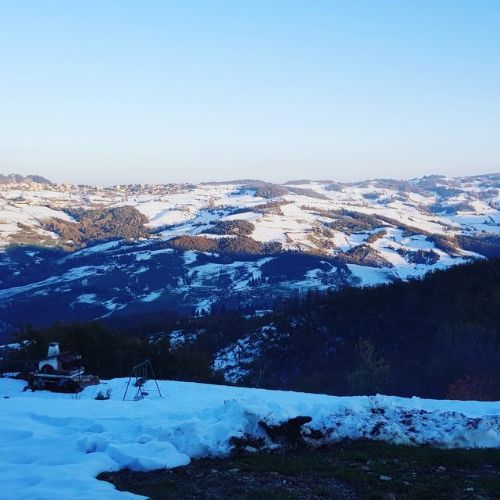 Un paesaggio innevato con un cielo azzurro sullo sfondo
