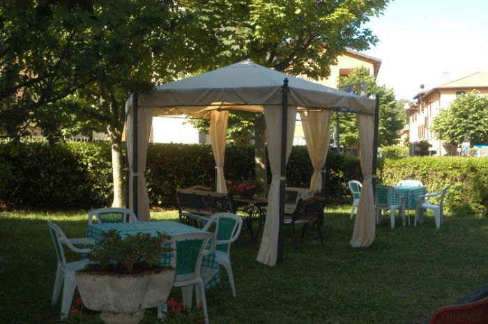 Un gazebo con tavoli e sedie sottostanti