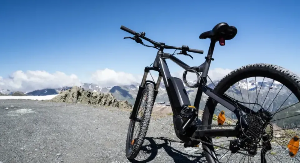 An electric bicycle is parked on top of a mountain.
