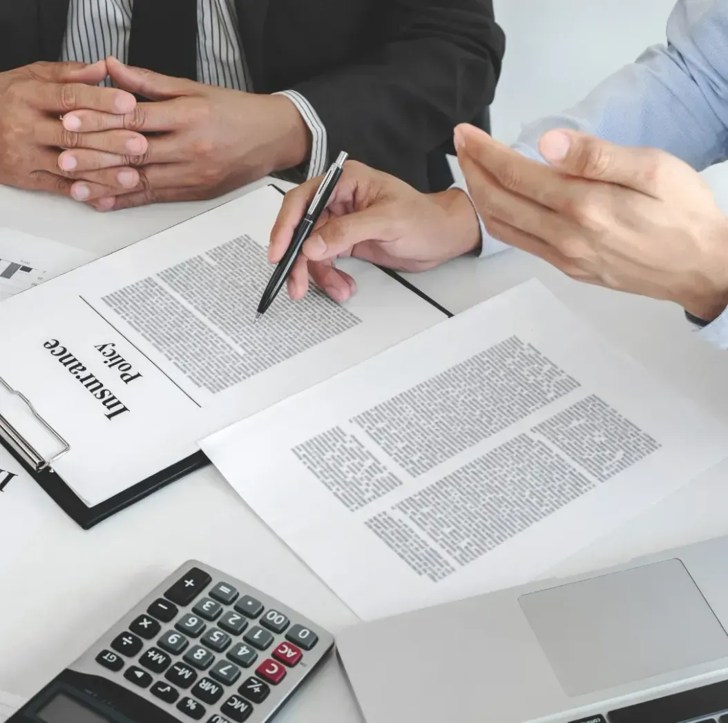 Two men are sitting at a table looking at a piece of paper.