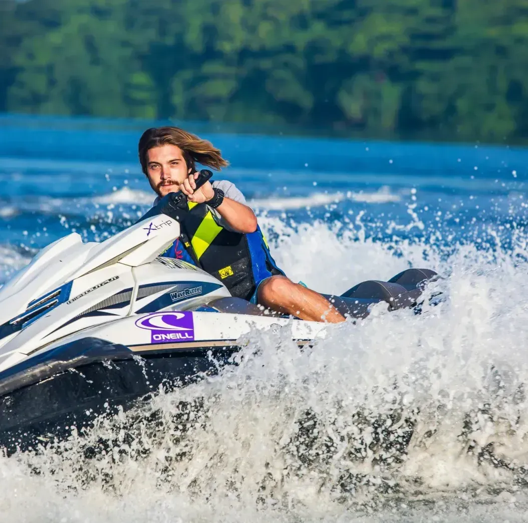 A man is riding a jet ski on a lake.