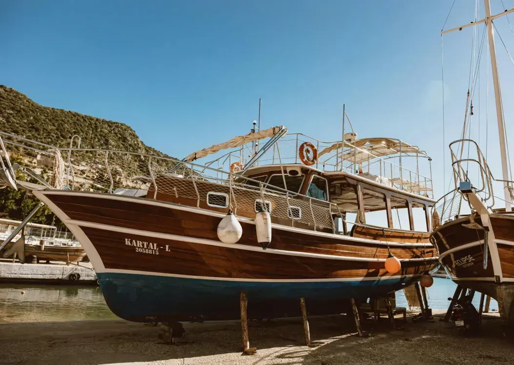 A group of wooden boats are docked in a harbor.